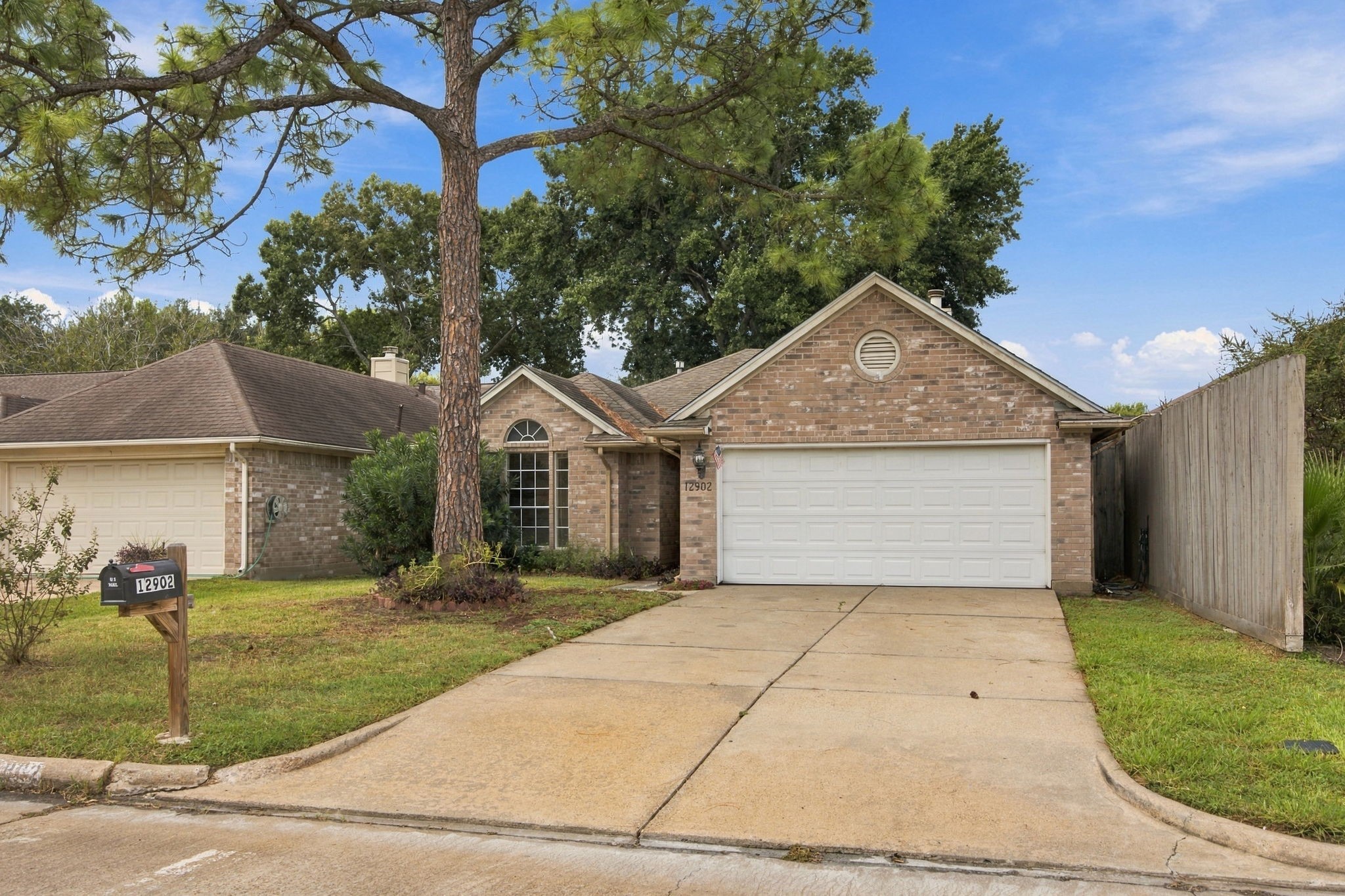 A double-width driveway leads to the garage, providing convenient off-street parking.