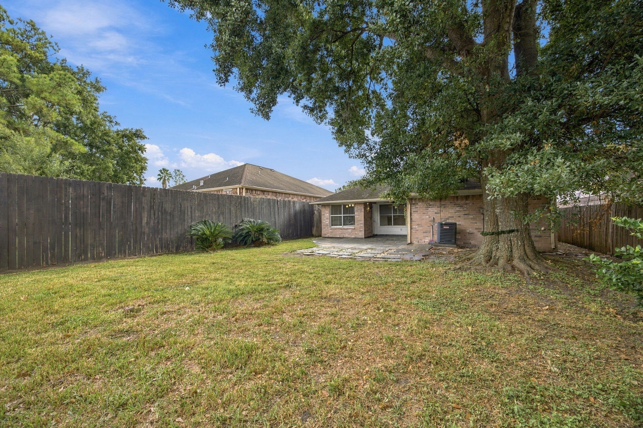 A mature shade tree anchors the lawn, with open space to create your own outdoor retreat.