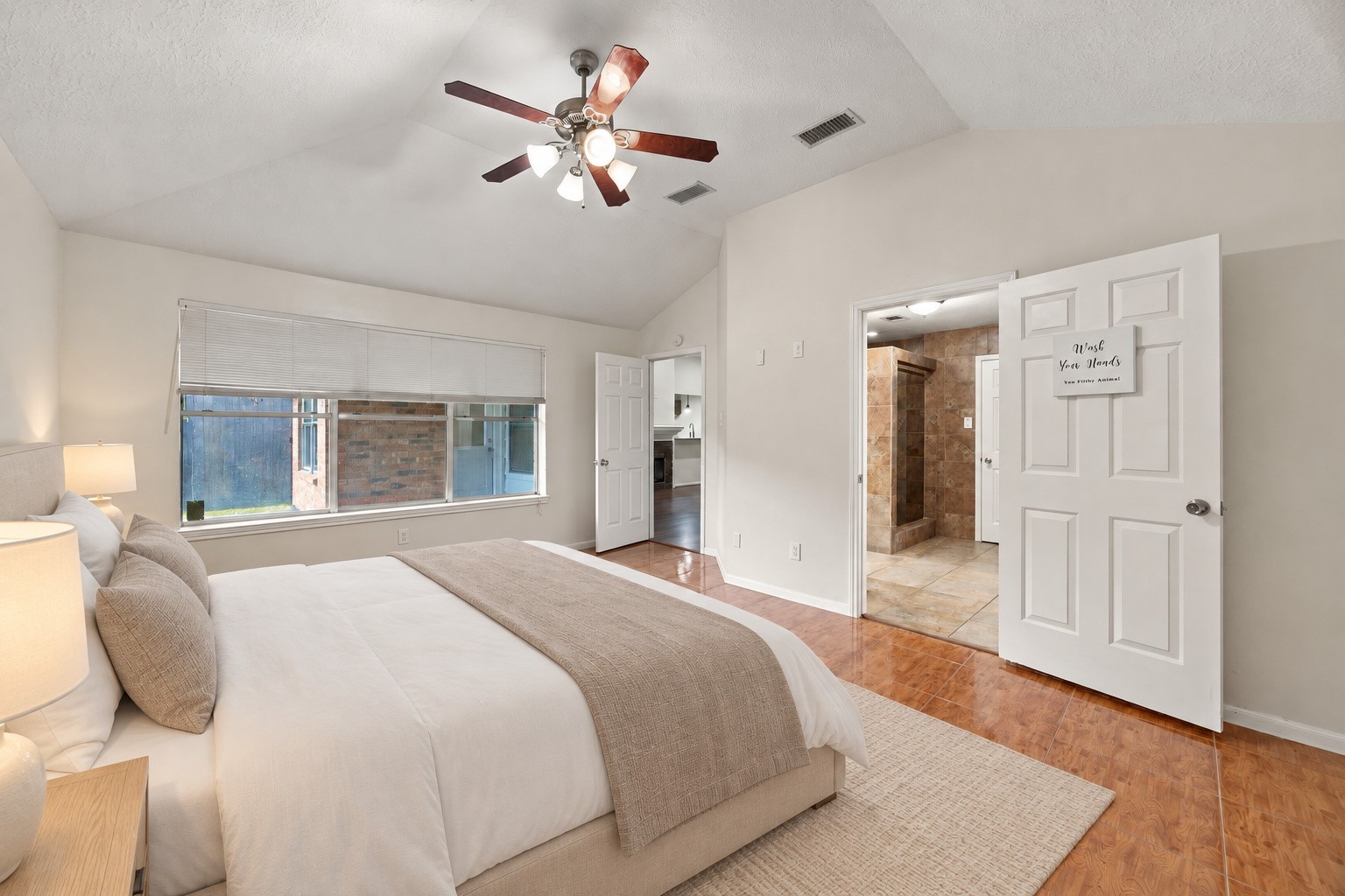 A wide window welcomes natural light, while the adjoining bathroom is easily accessible from the bedroom. Virtually staged