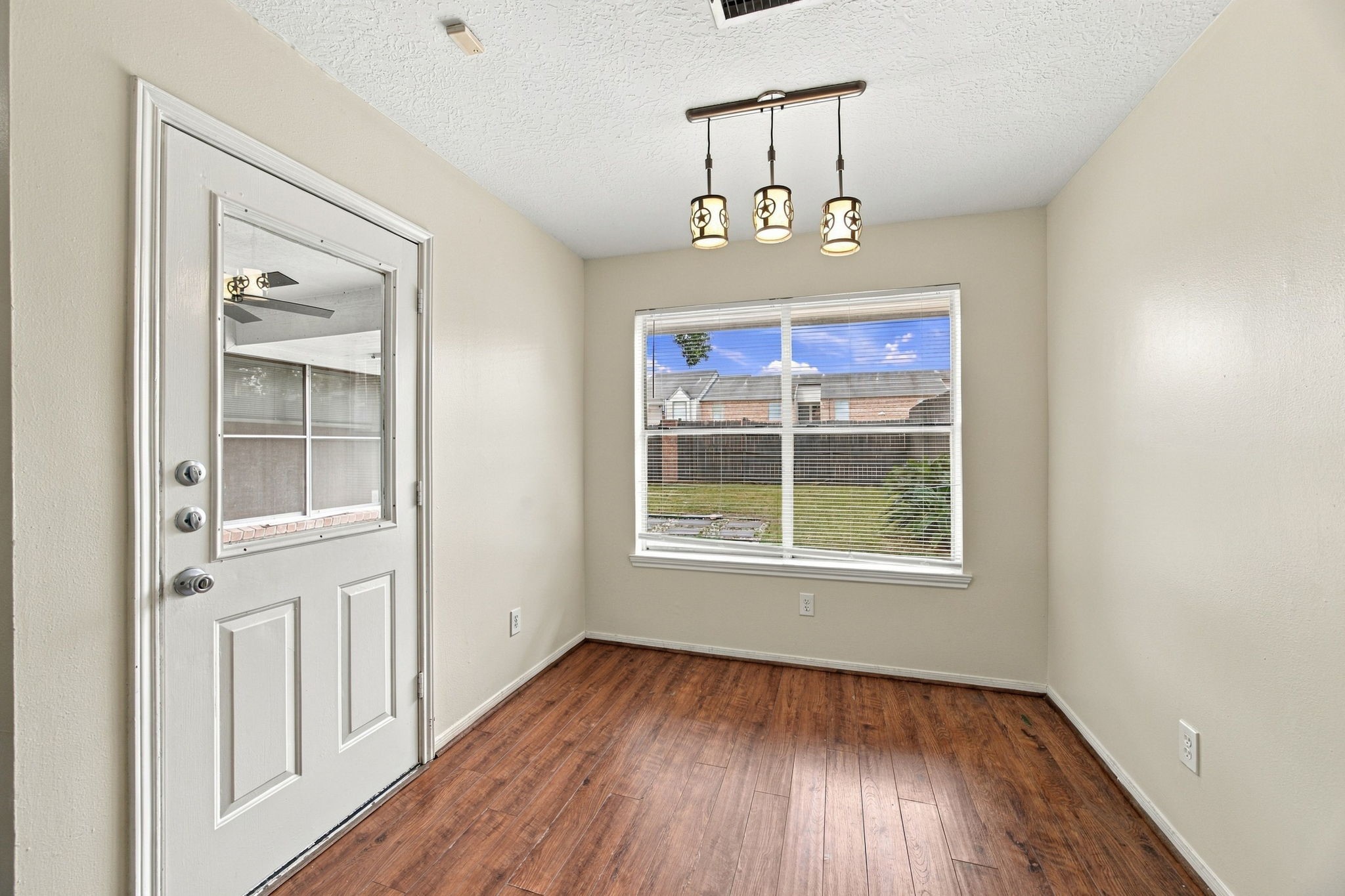 A sunny breakfast nook offers a casual dining spot beside a large window and an exterior door.