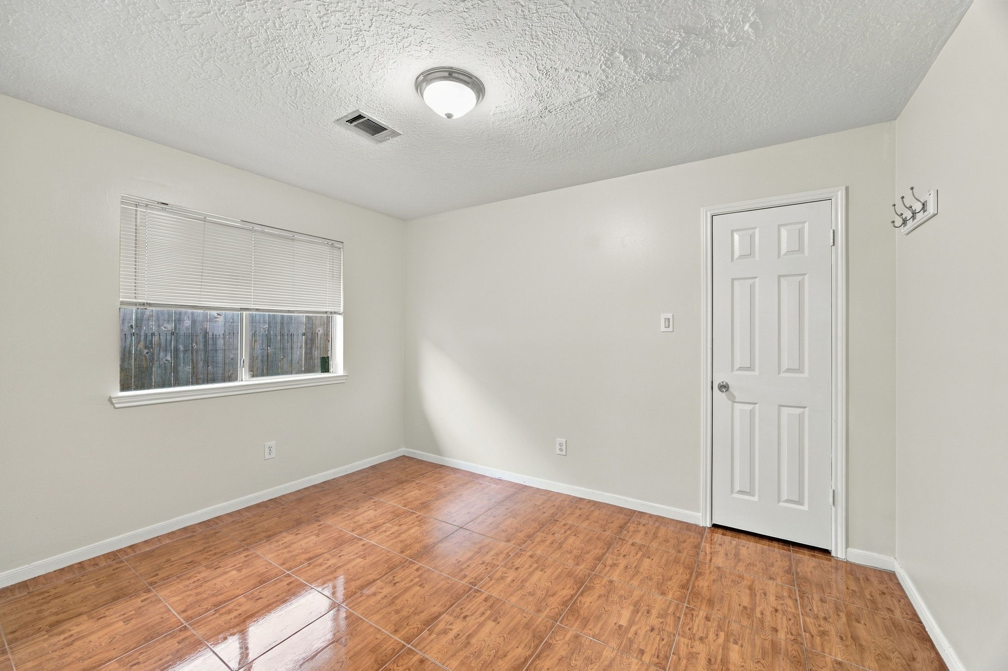 Natural light and wood-look flooring create a welcoming bedroom that could also serve as a home office or guest room.