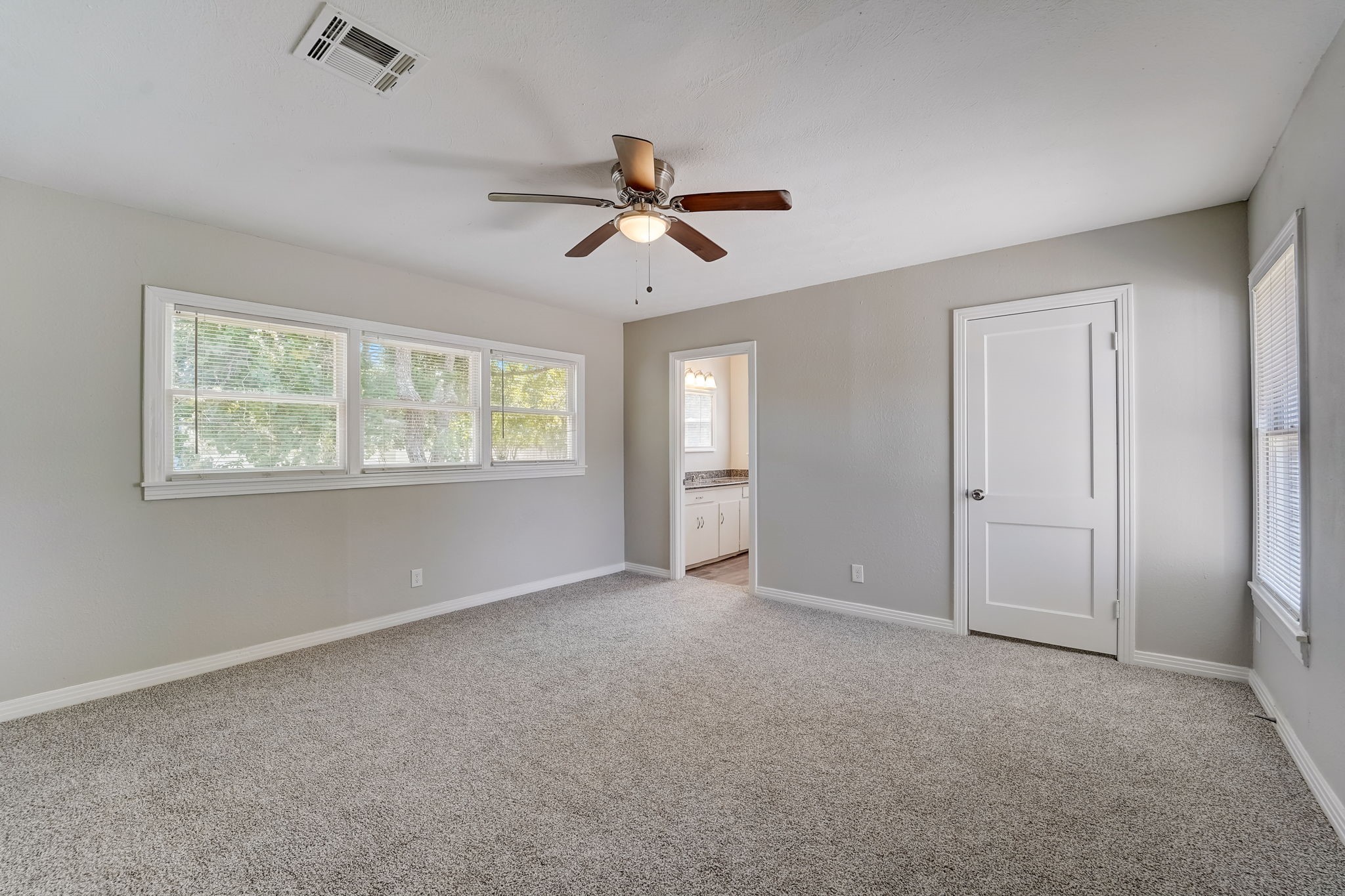Spacious primary bedroom that features an en-suite bathroom and walk-in closet.