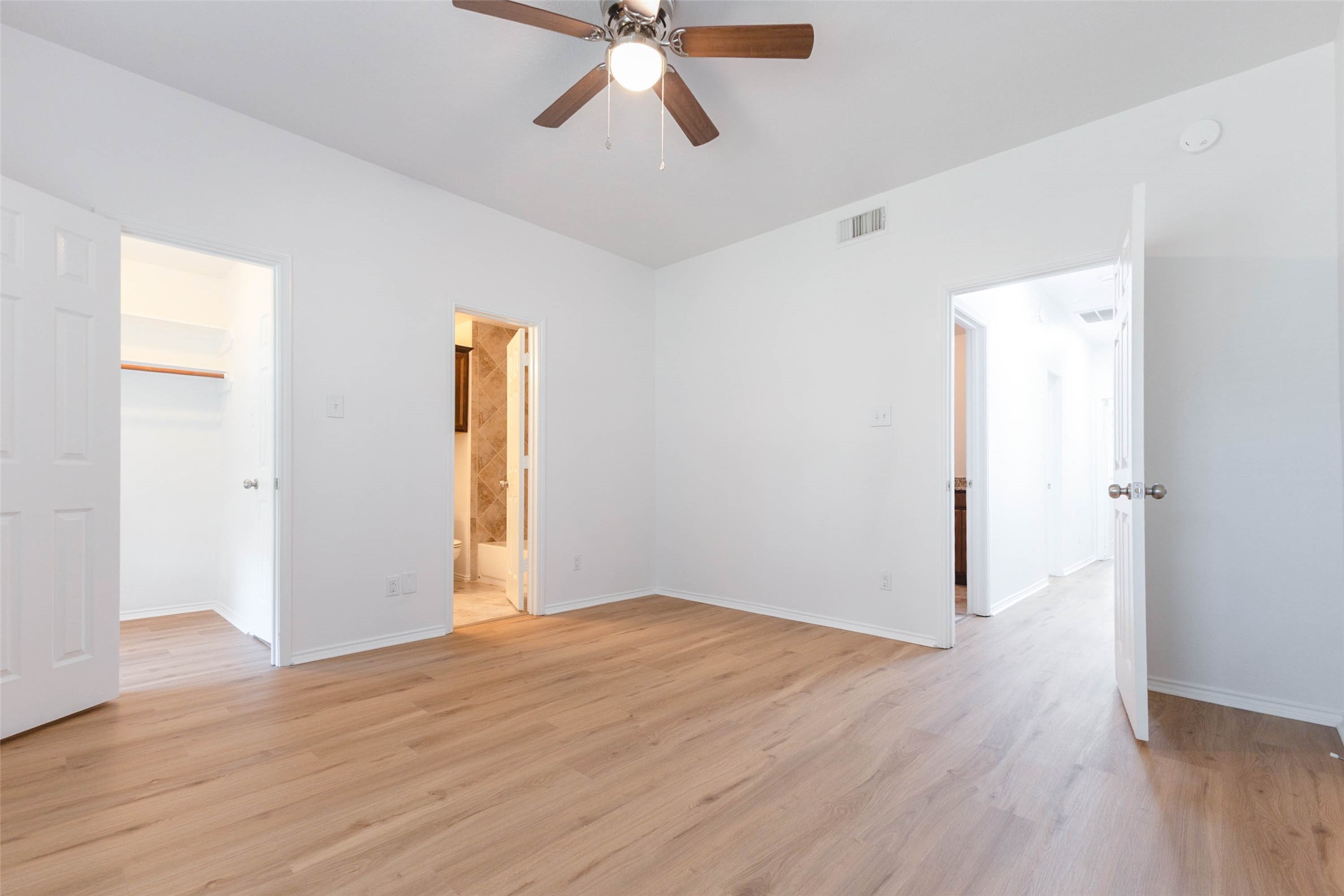 This alternate view of the first-floor secondary bedroom highlights the added convenience of a private ensuite bath & generous walk-in closet. Thoughtfully designed for comfort & privacy, this inviting space offers an ideal retreat for family members or overnight guests.