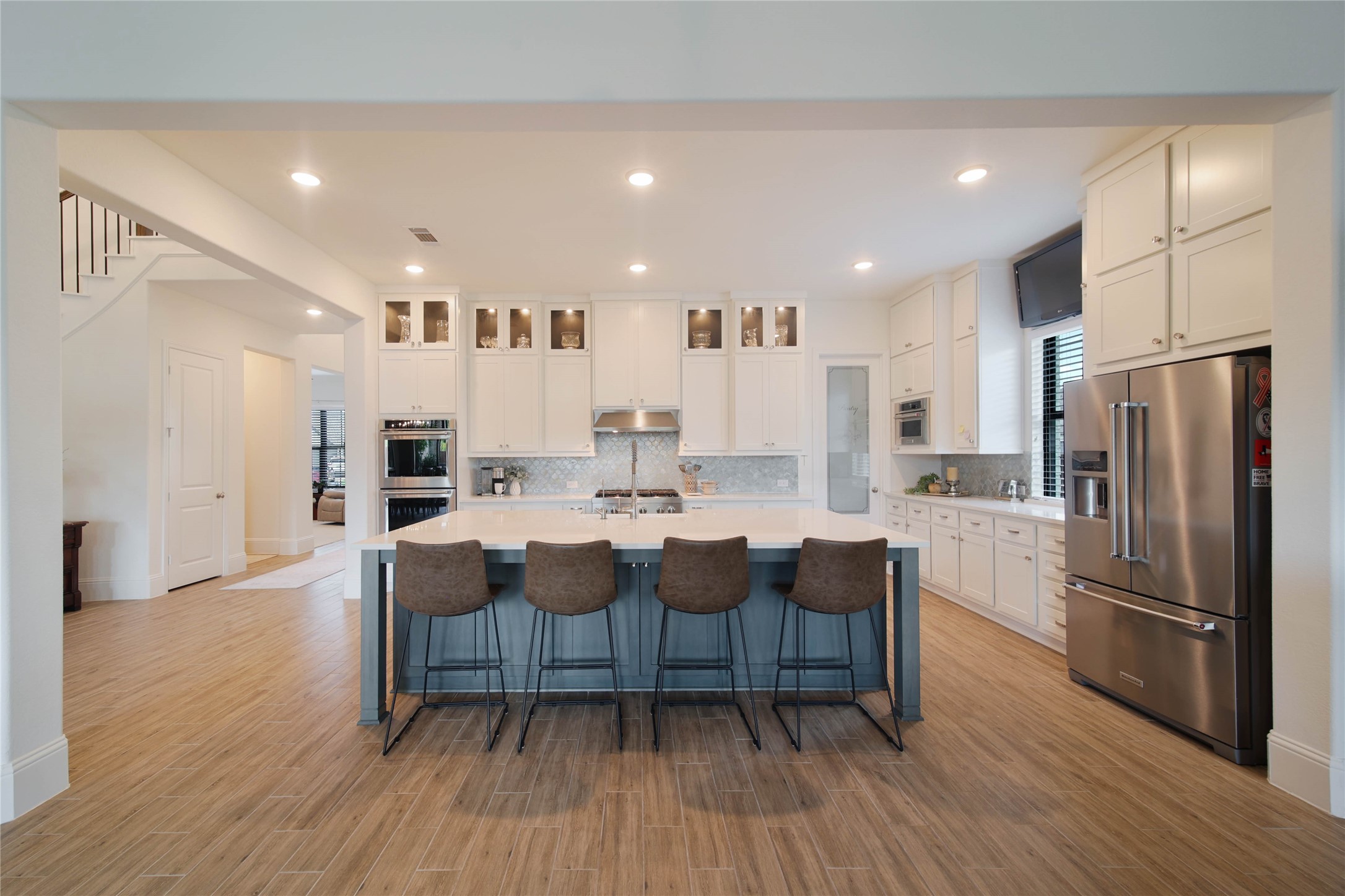 The kitchen boasts an oversized center island with luxurious quartz countertops, sure to become the favorite gathering spot for family and friends.