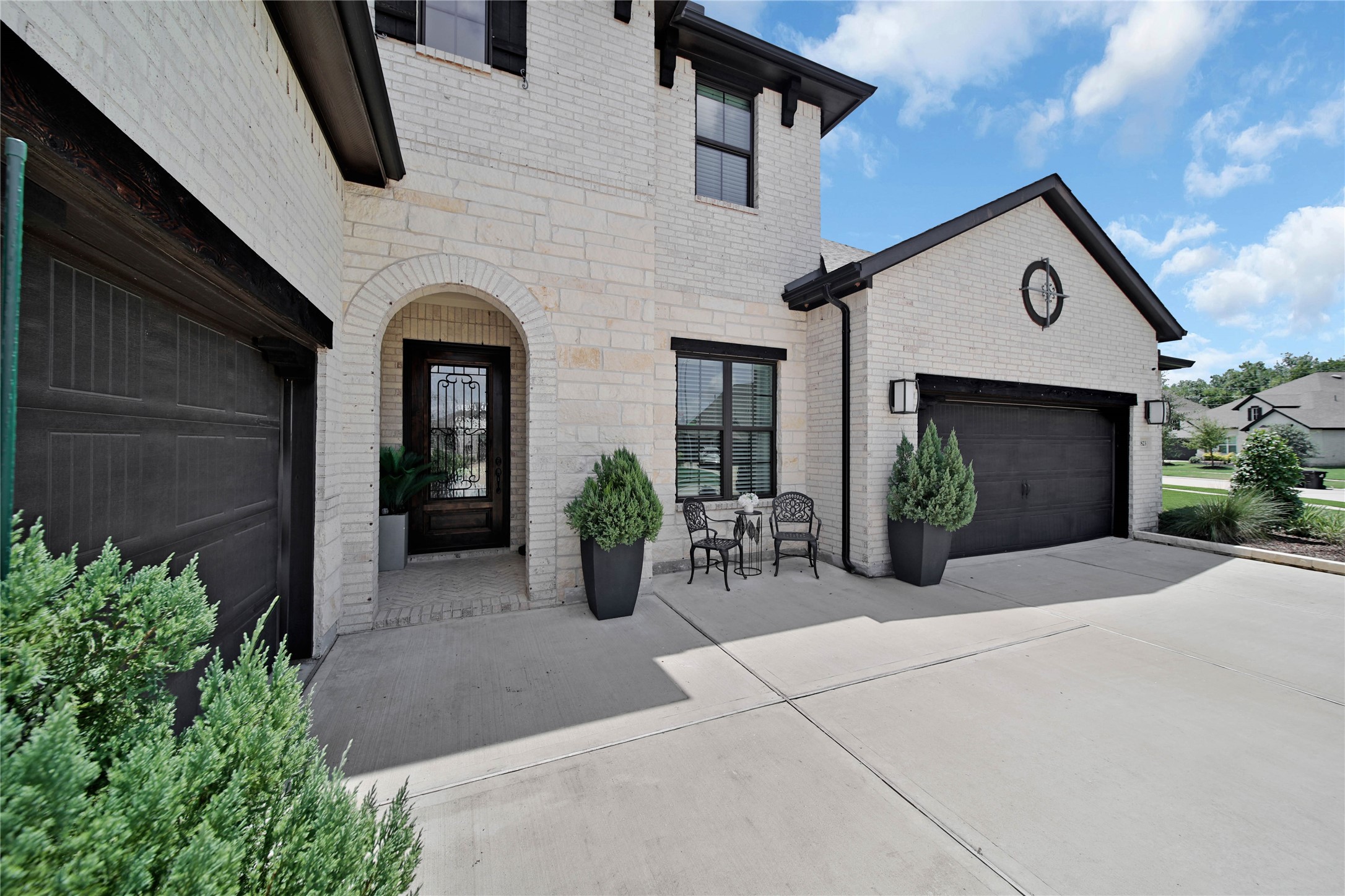 An arched entry welcomes guests, while a cozy sitting area offers the perfect spot to enjoy your morning coffee outdoors.
