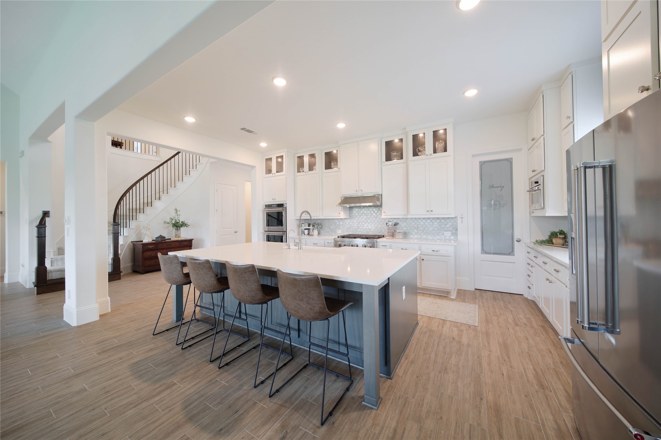 The gourmet kitchen is a chefs dream, featuring upgraded floor-to-ceiling cabinetry, a spacious layout, and upgraded KitchenAid stainless steel appliances.