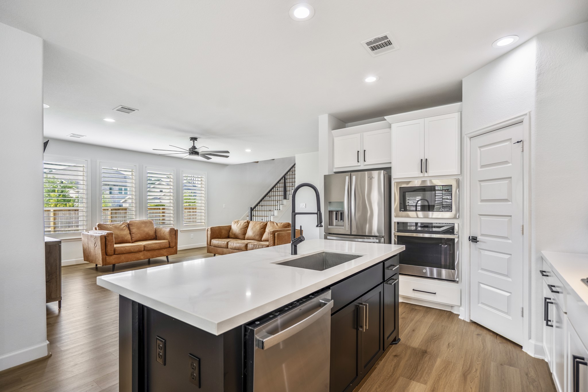 This modern open plan is brightened by ample natural light from multiple windows with plantation shutters.