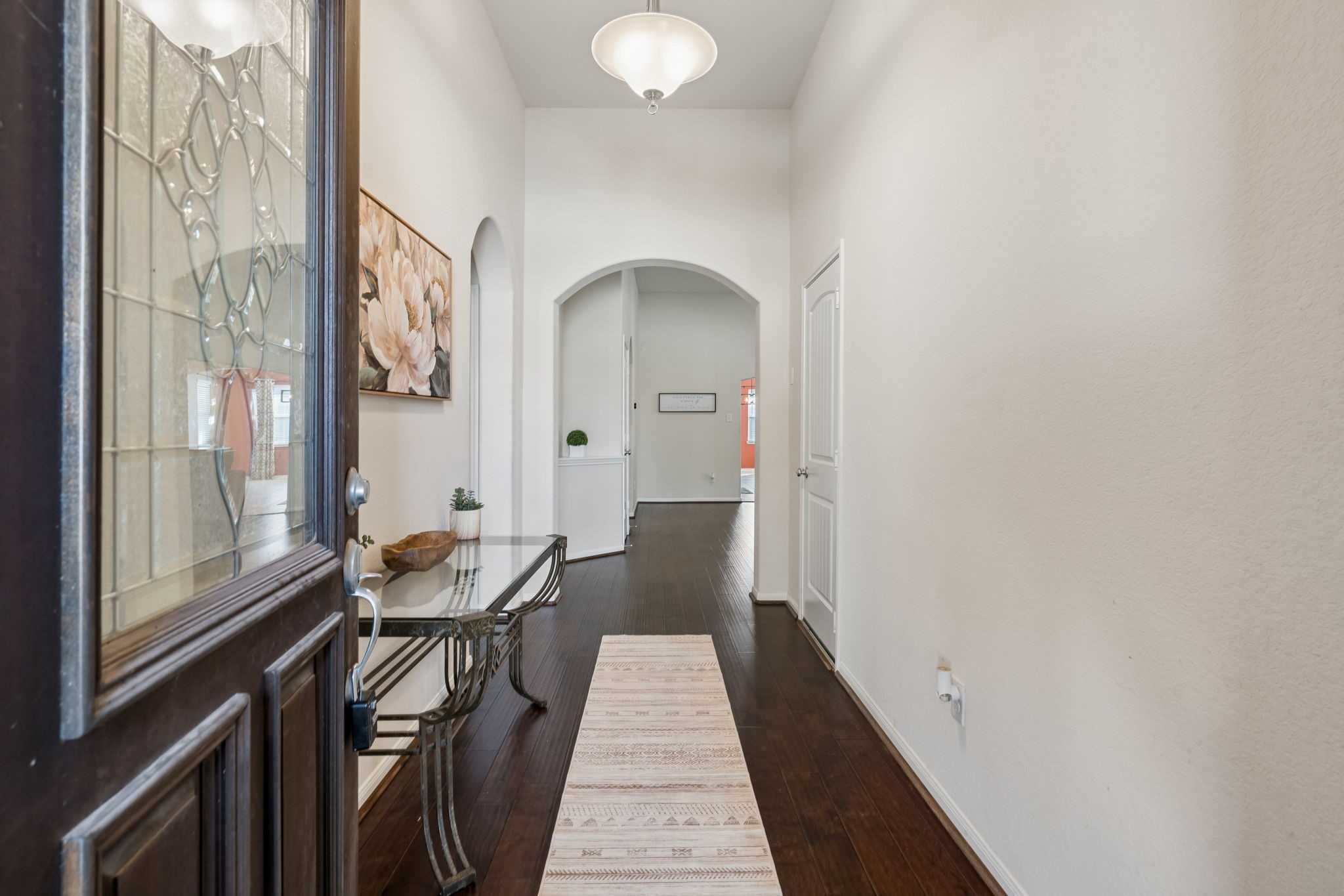 A welcoming entrance that sets the tone with soaring ceilings, rich wood flooring and graceful archways