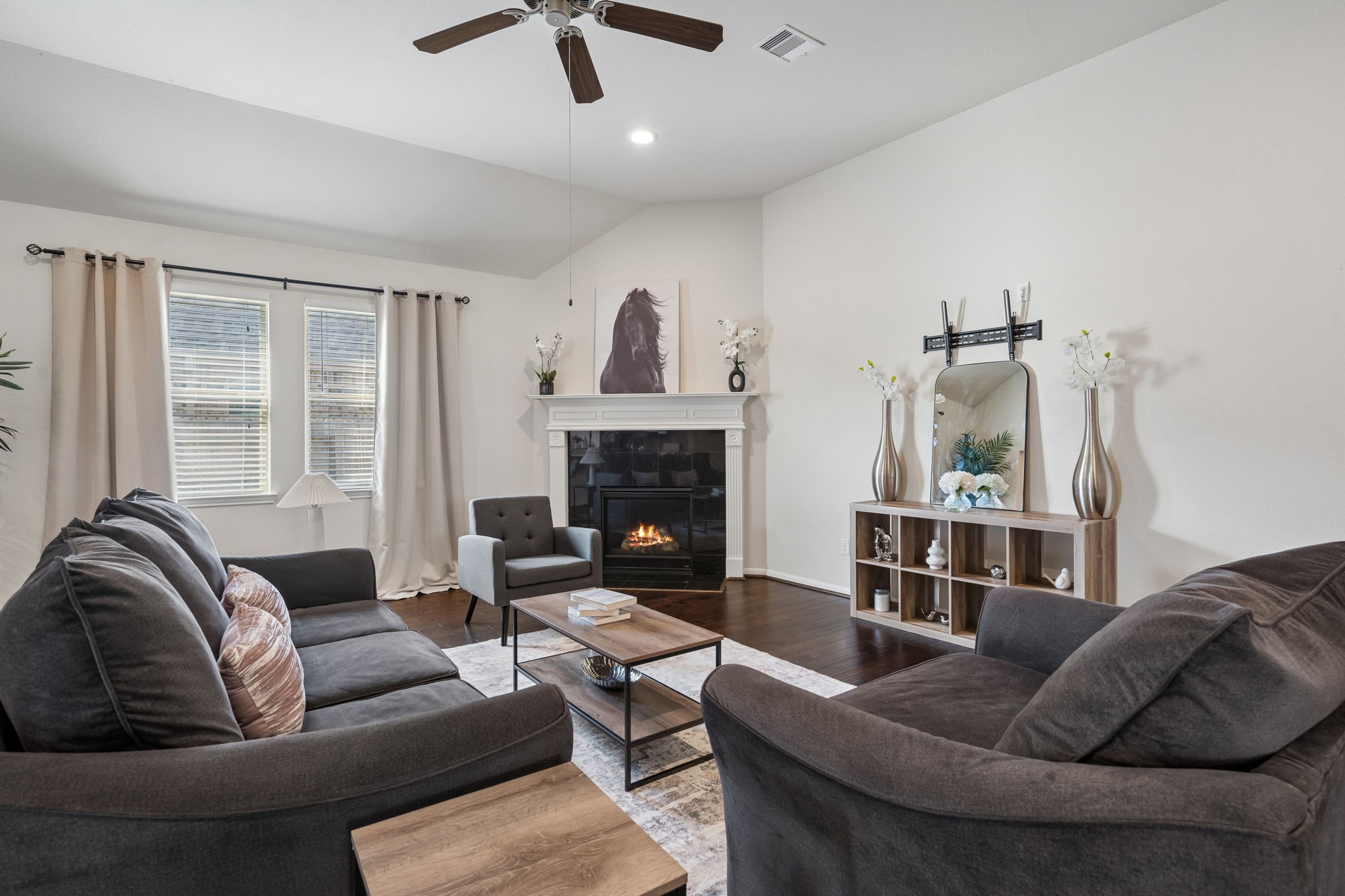 Large open living room with fireplace & large window.