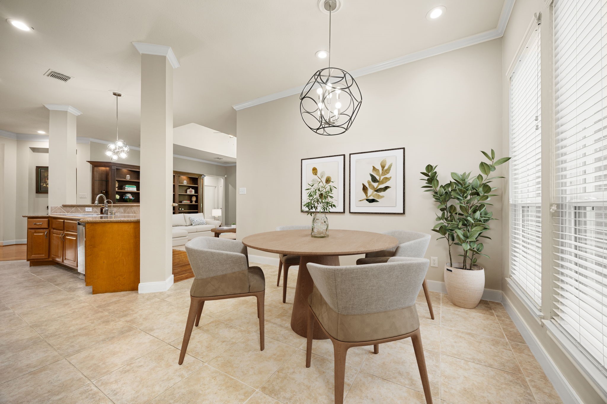 This sunlit breakfast nook sits right off the kitchen, serving as the perfect spot for casual morning coffee or family meals. Large windows fill the space with cheerful morning light, while a stylish, contemporary orb chandelier adds a chic, modern touch to your everyday dining experience.