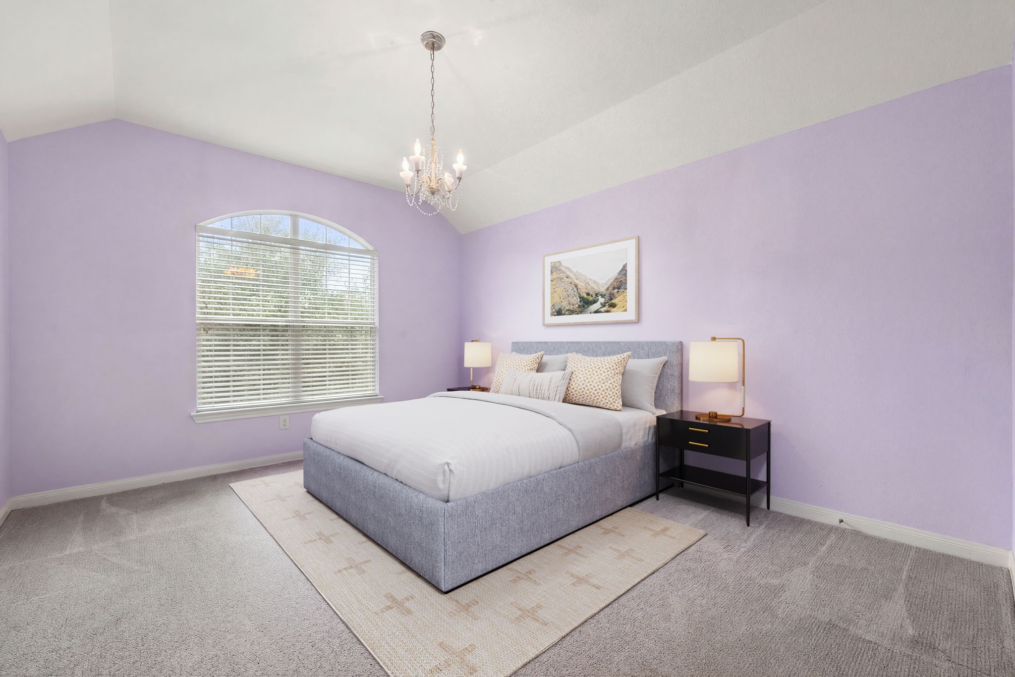Painted in a soft, cheerful pastel shade, this large bedroom boasts a beautiful arched feature window that lets in plenty of natural light. High vaulted ceilings, an elegant modern chandelier, and plush carpeting make this a charming and comfortable retreat for children or guests.