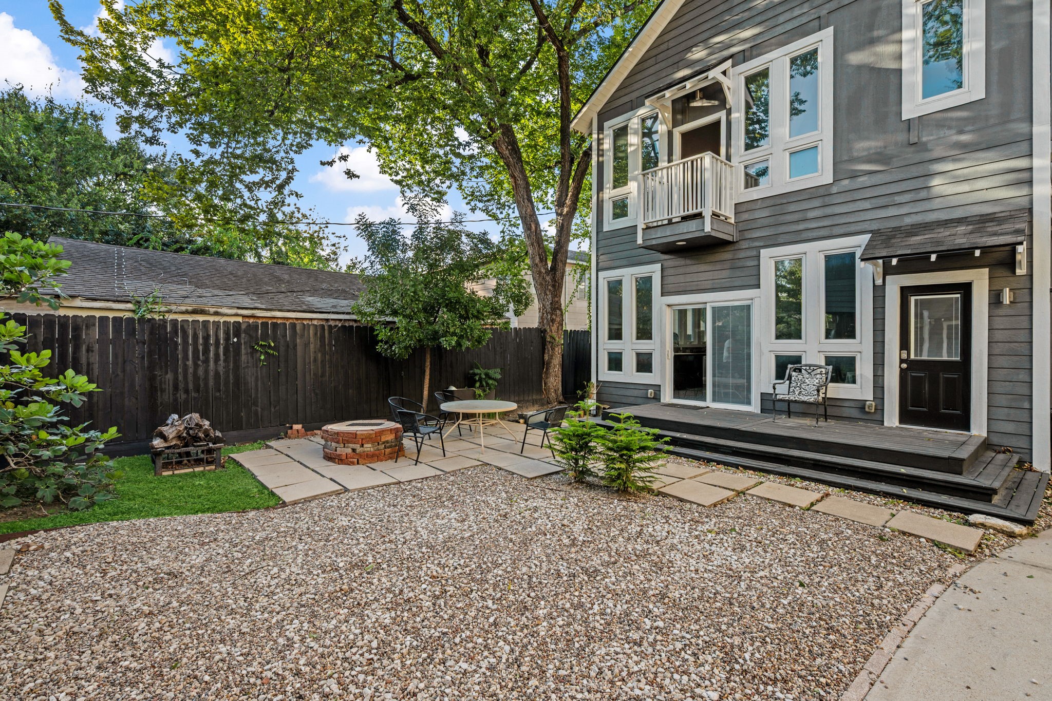 A gravel side yard with space for a fire pit.