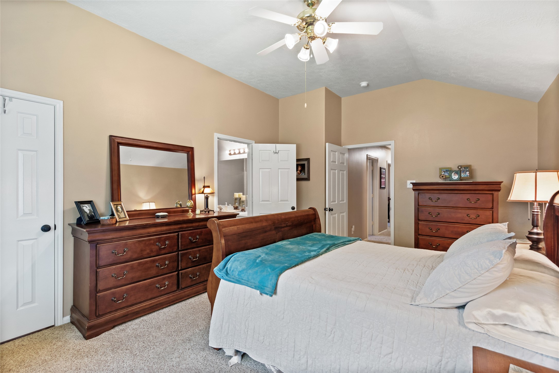 Generous primary bedroom featuring an en-suite bathroom, ample natural light, and a warm and inviting atmosphere.