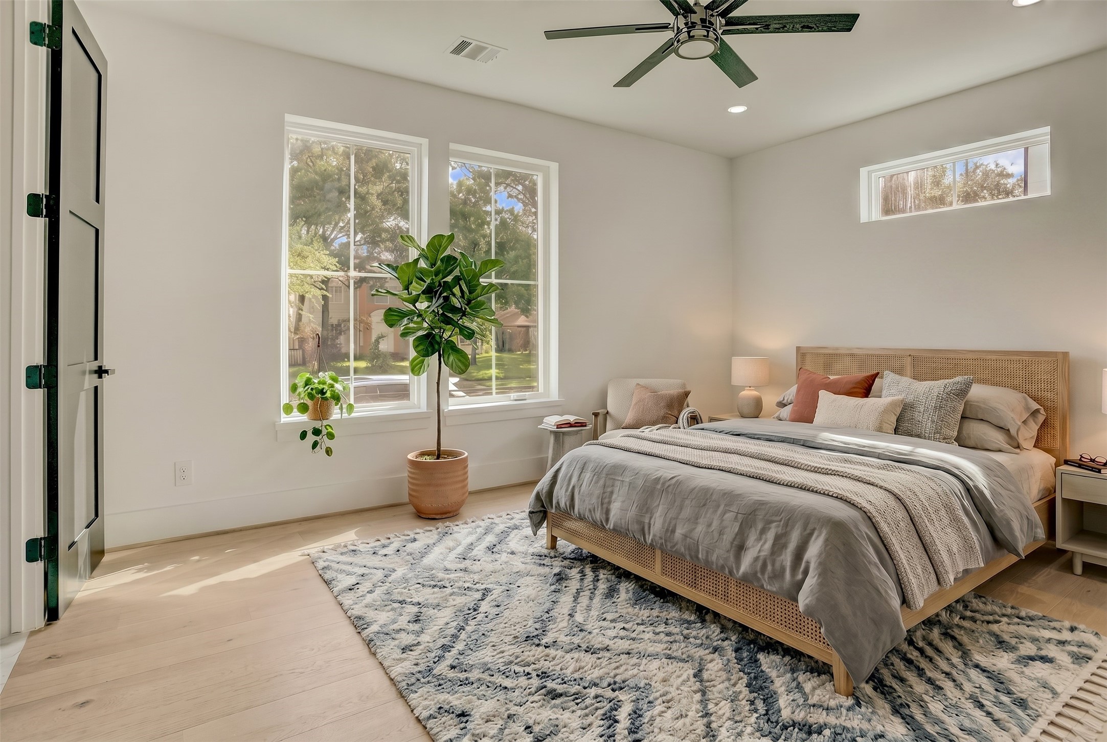 The first floor bedroom suite offers a sizable room and views of the yard space. Virtually staged photo.