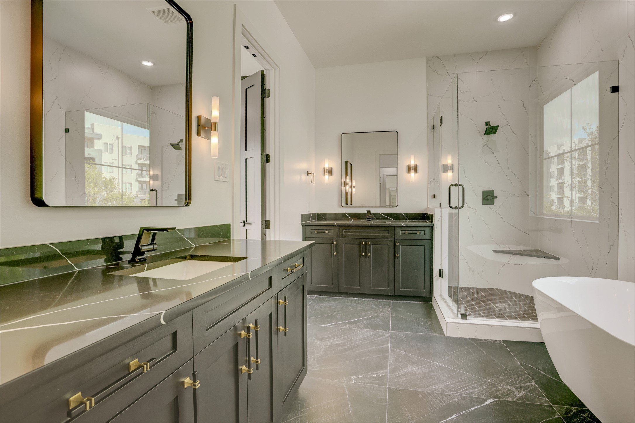 The spacious primary bathroom offers dual vanities, walk-in shower, separate soaker tub, and plenty of natural light.