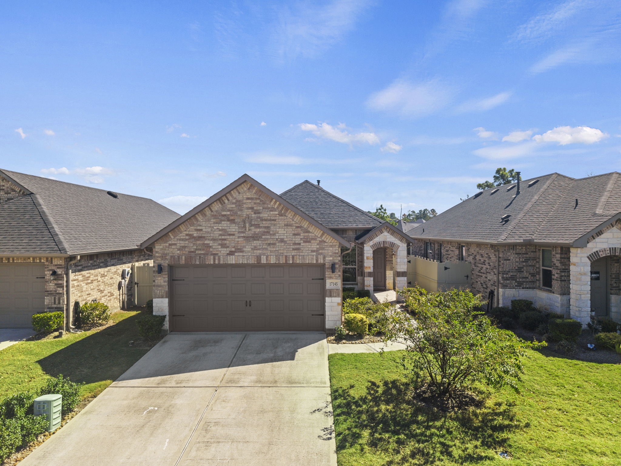 Beautiful single-story brick home with charming curb appeal, a welcoming covered entry, and a spacious driveway leading to a two-car garage.