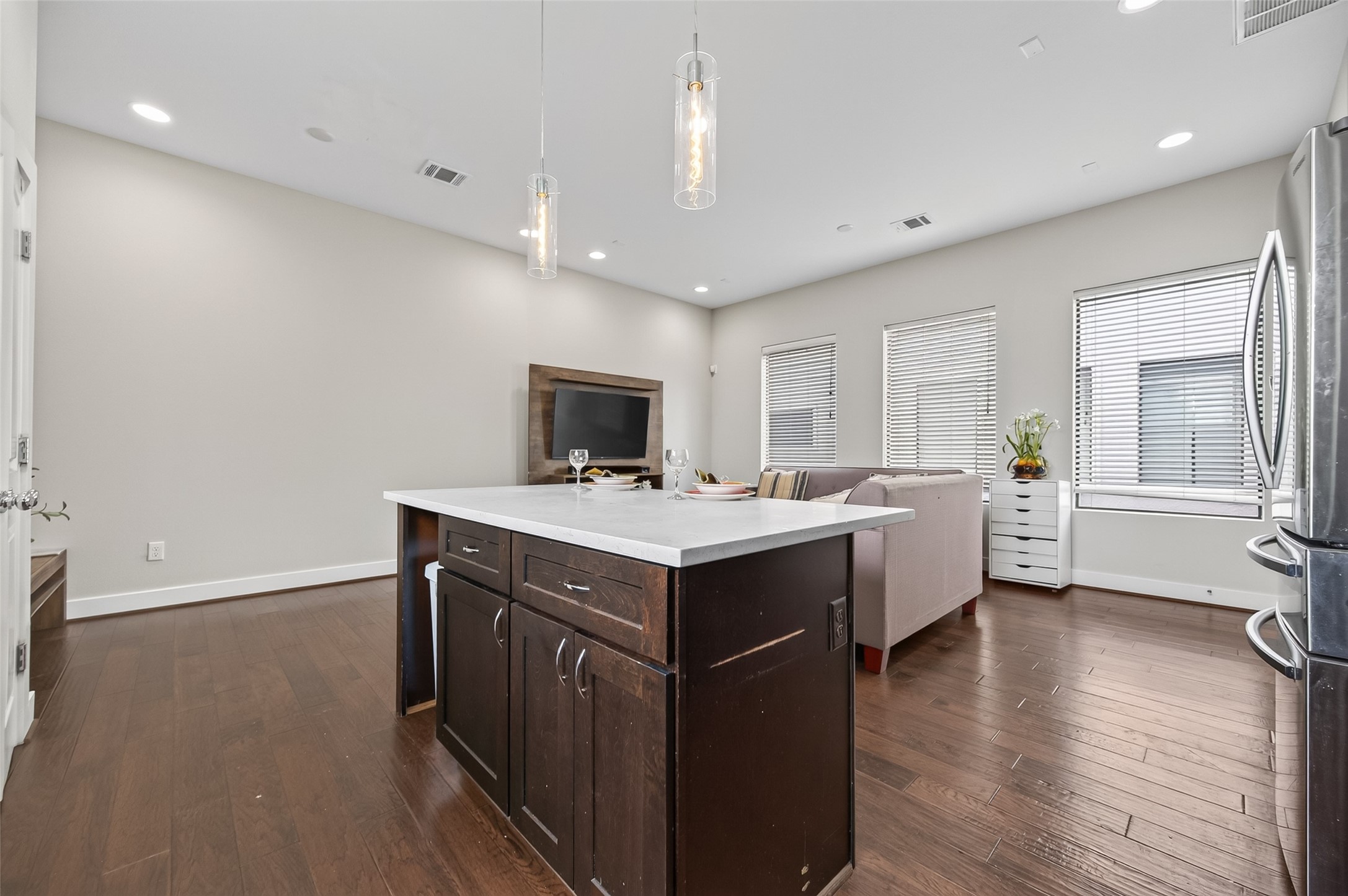Bright and modern kitchen featuring sleek dark cabinets, a stainless steel dishwasher, and a chic subway tile backsplash, accented by large windows for natural light.