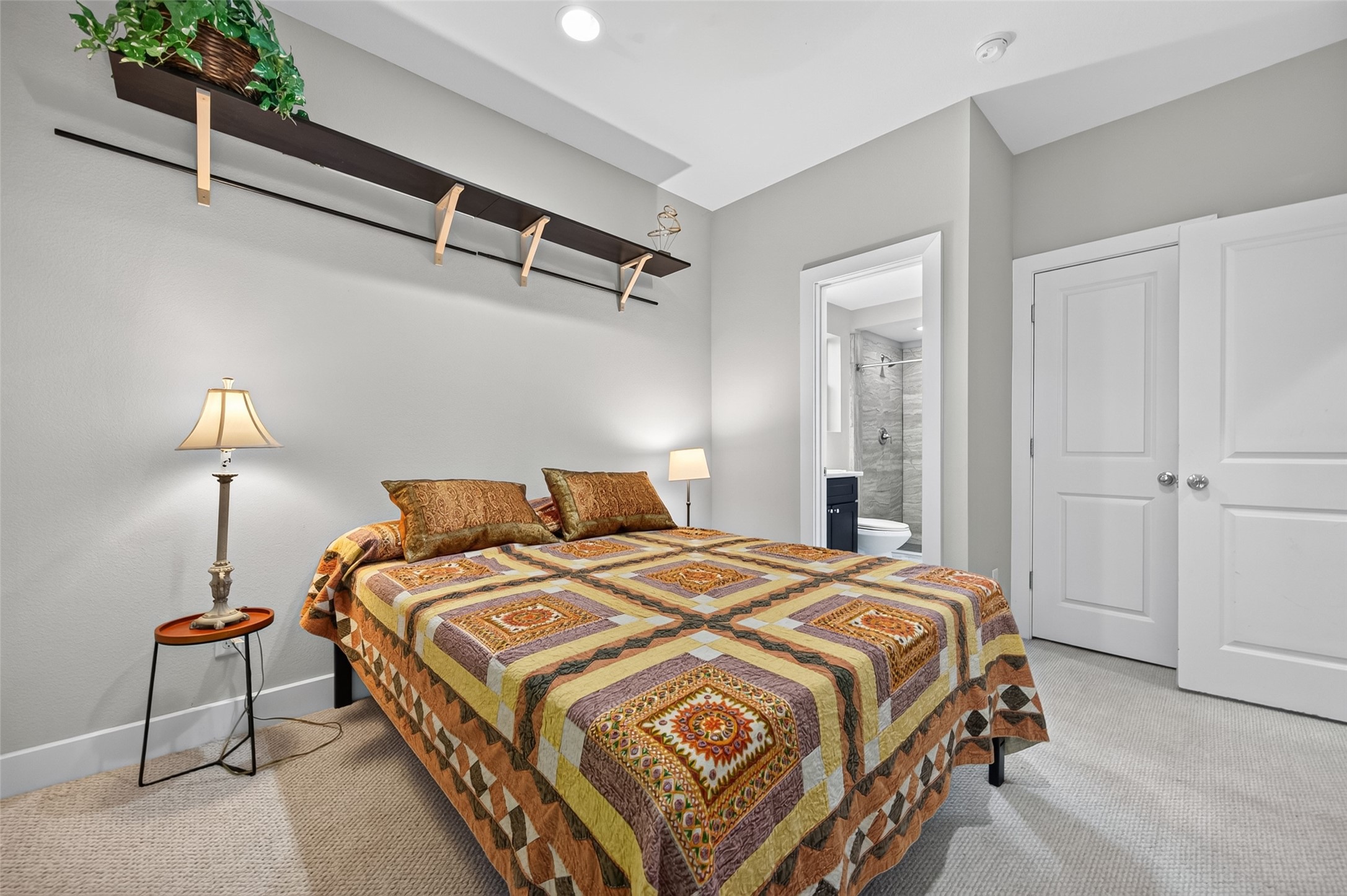 Cozy bedroom with a warm color palette, featuring a comfortable bed, soft lighting, and a window offering natural light and greenery views.