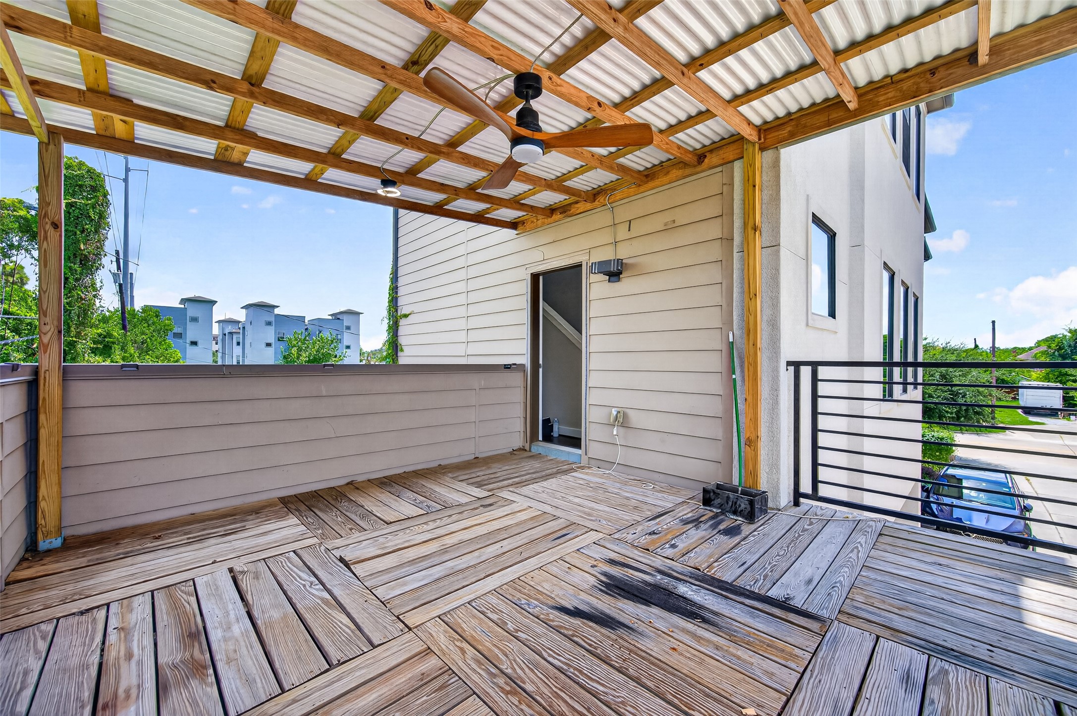 Charming outdoor patio offers a cozy seating area under a stylish pergola, perfect for relaxing or entertaining, complete with lush greenery and a grill station.