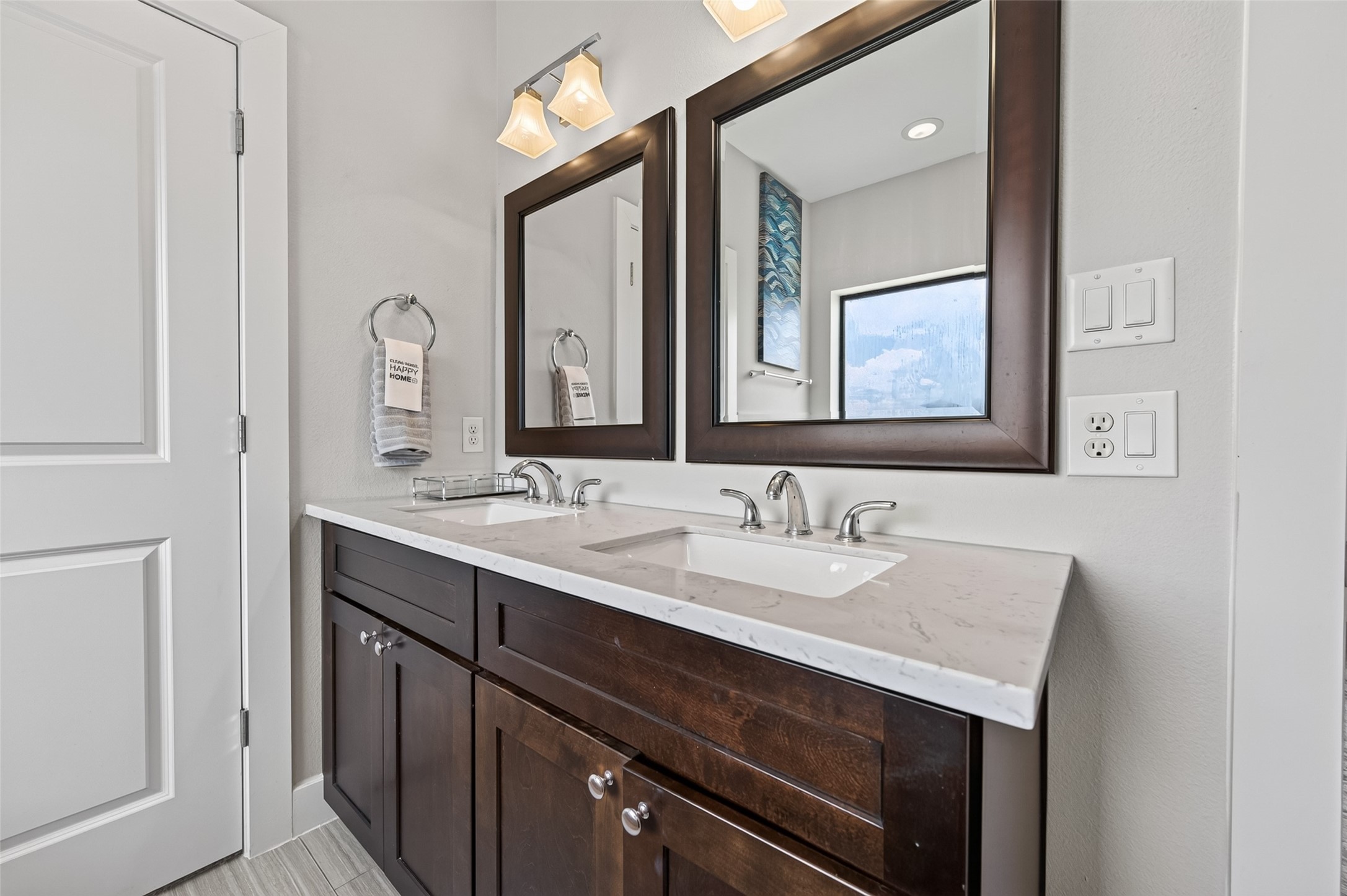 Elegant bathroom featuring a spacious bathtub, double vanity with sleek countertops, and modern fixtures, all accented by stylish tile flooring and ample natural light.