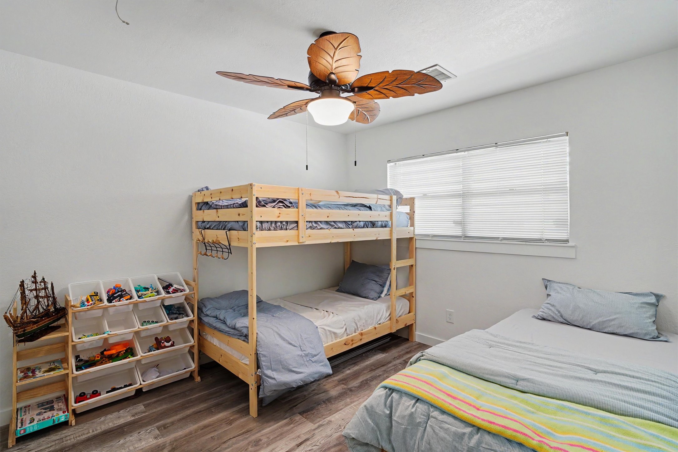 This spacious guest bedroom offers plenty of room for multiple beds, making it the perfect setup for hosting family and friends. Comfortable, versatile, and ready for overnight guests to settle in and stay awhile