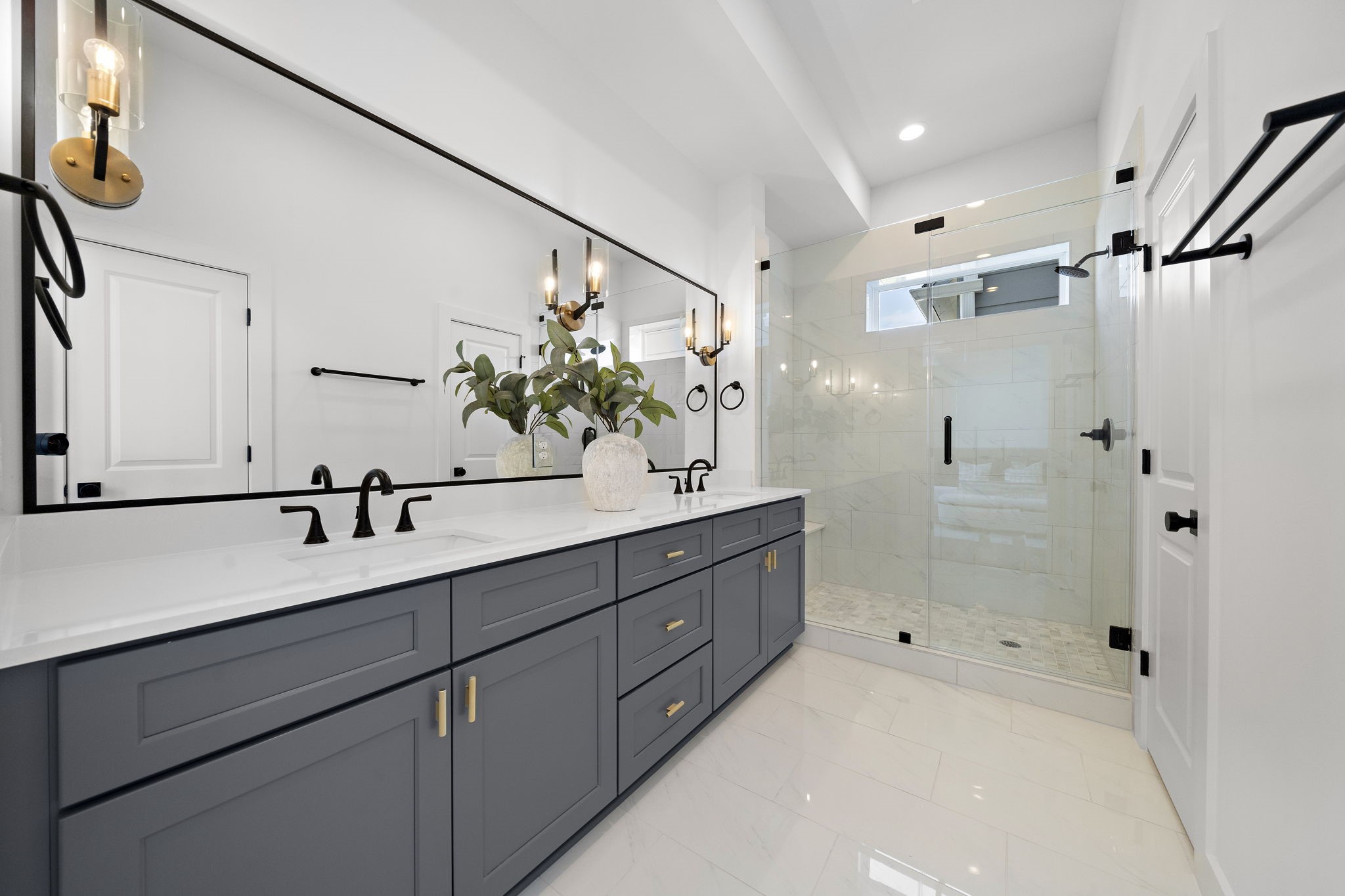 Primary Bathroom with dual vanities and and oversized glass walk-in shower.