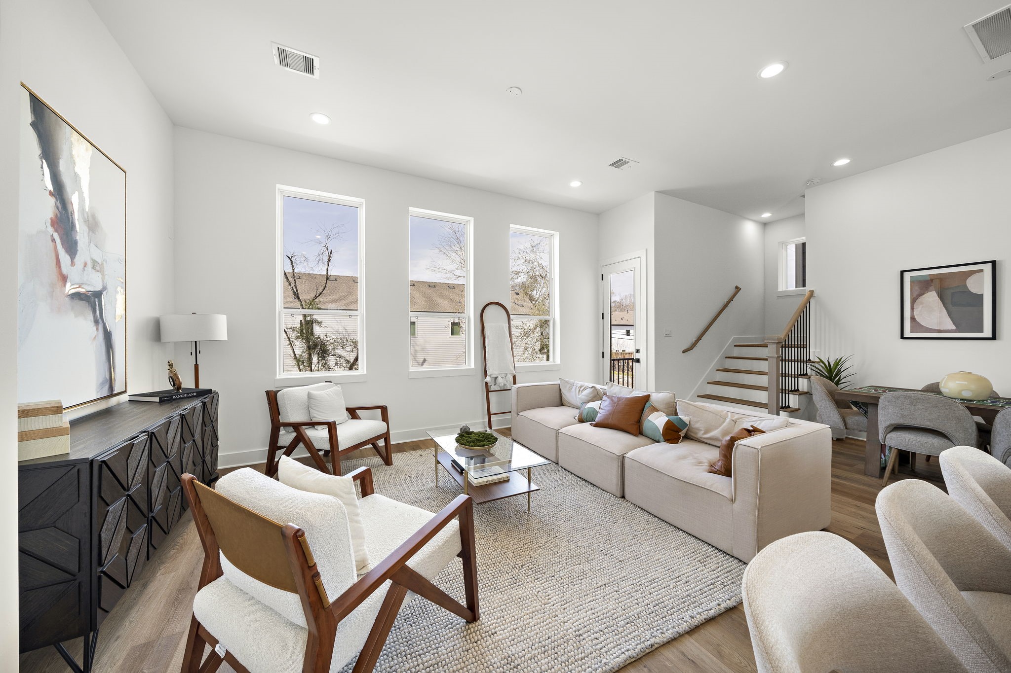 Bright and inviting living area featuring large windows and an open layout perfect for relaxation and entertaining.