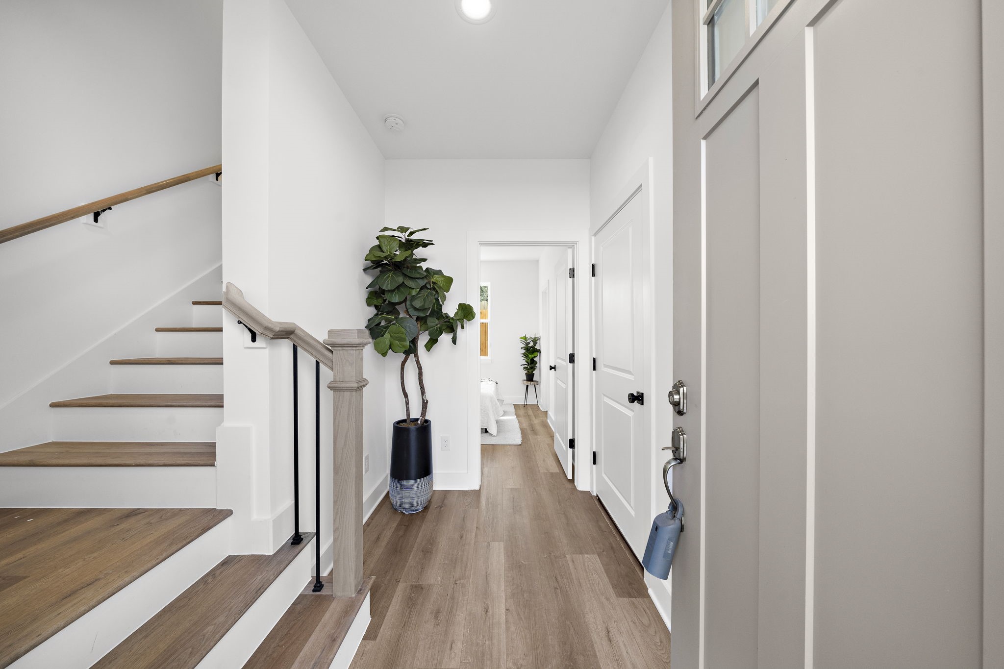 Step into a bright and welcoming foyer, featuring sleek hardwood floors and modern finishes, seamlessly guiding you into the heart of the home.