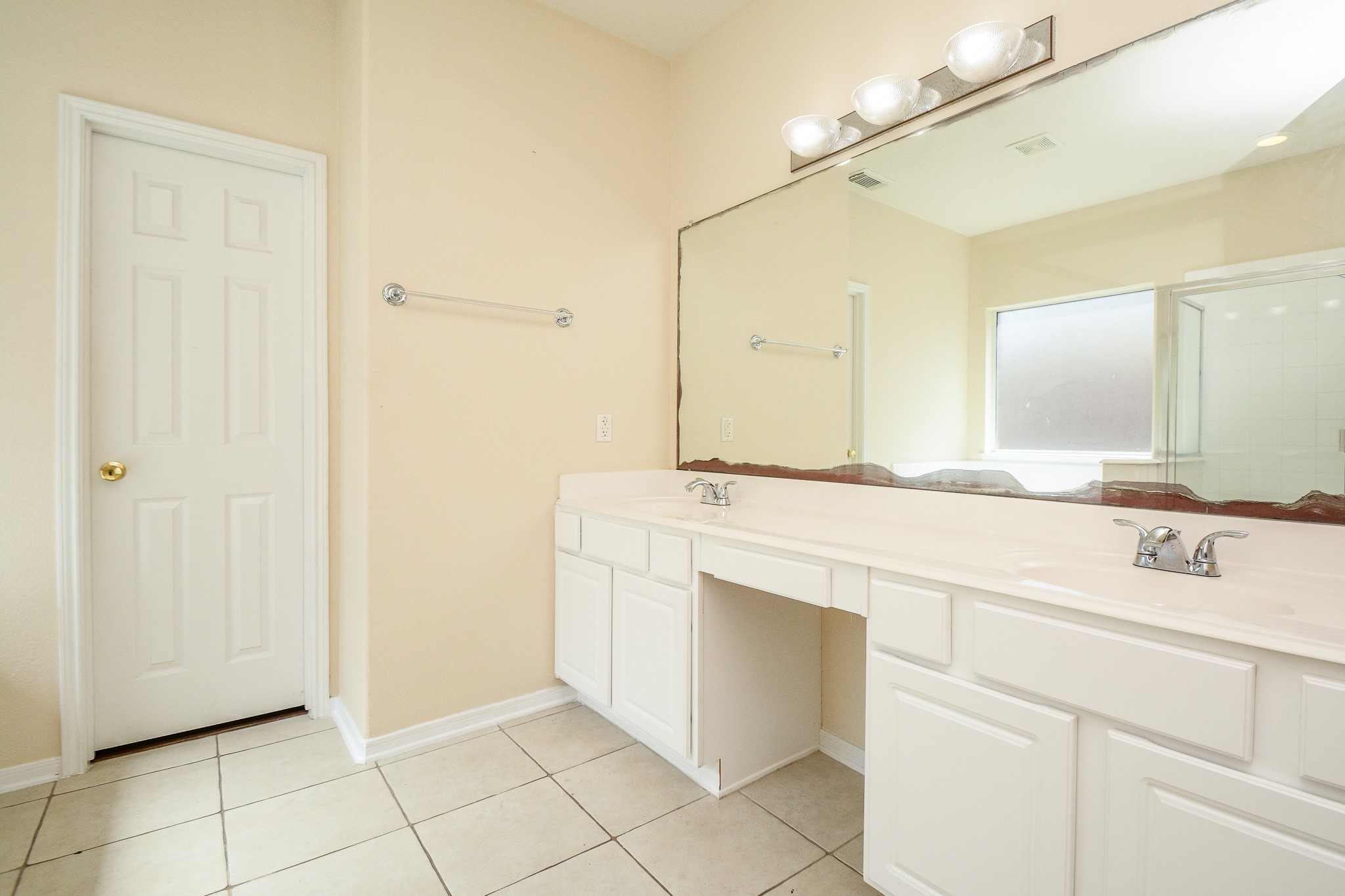 Primary en suite with double sinks and vanity/make up area- lots of cabinet storage and countertop space! Door leads to BIG walk in closet