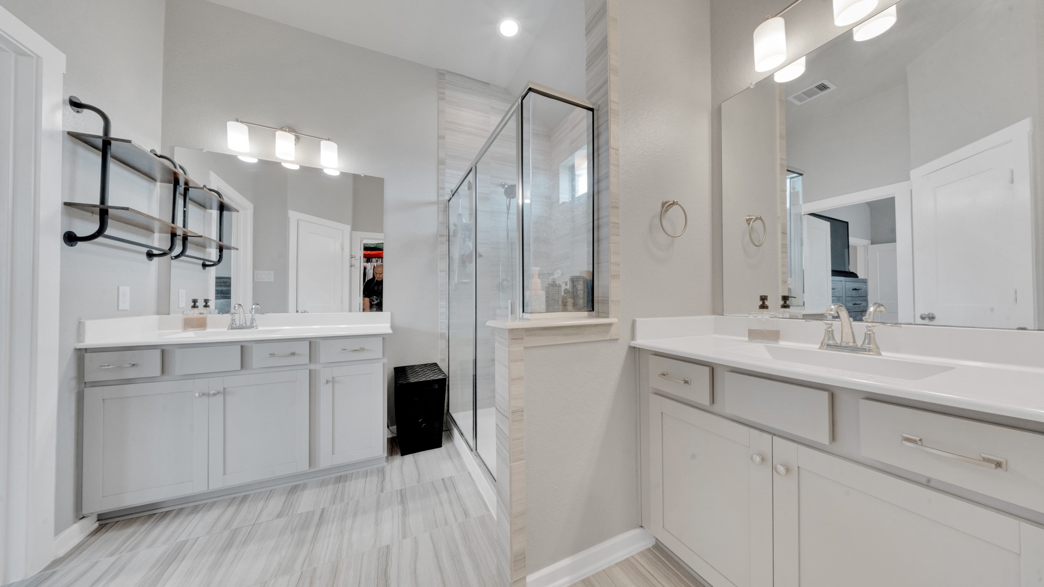 Large walk-in shower with modern tile surround and generous vanity space for added convenience.