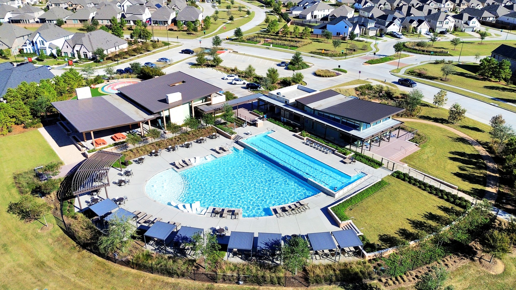 Resort-style community pool, lap lanes, clubhouse, and shaded lounging areas.