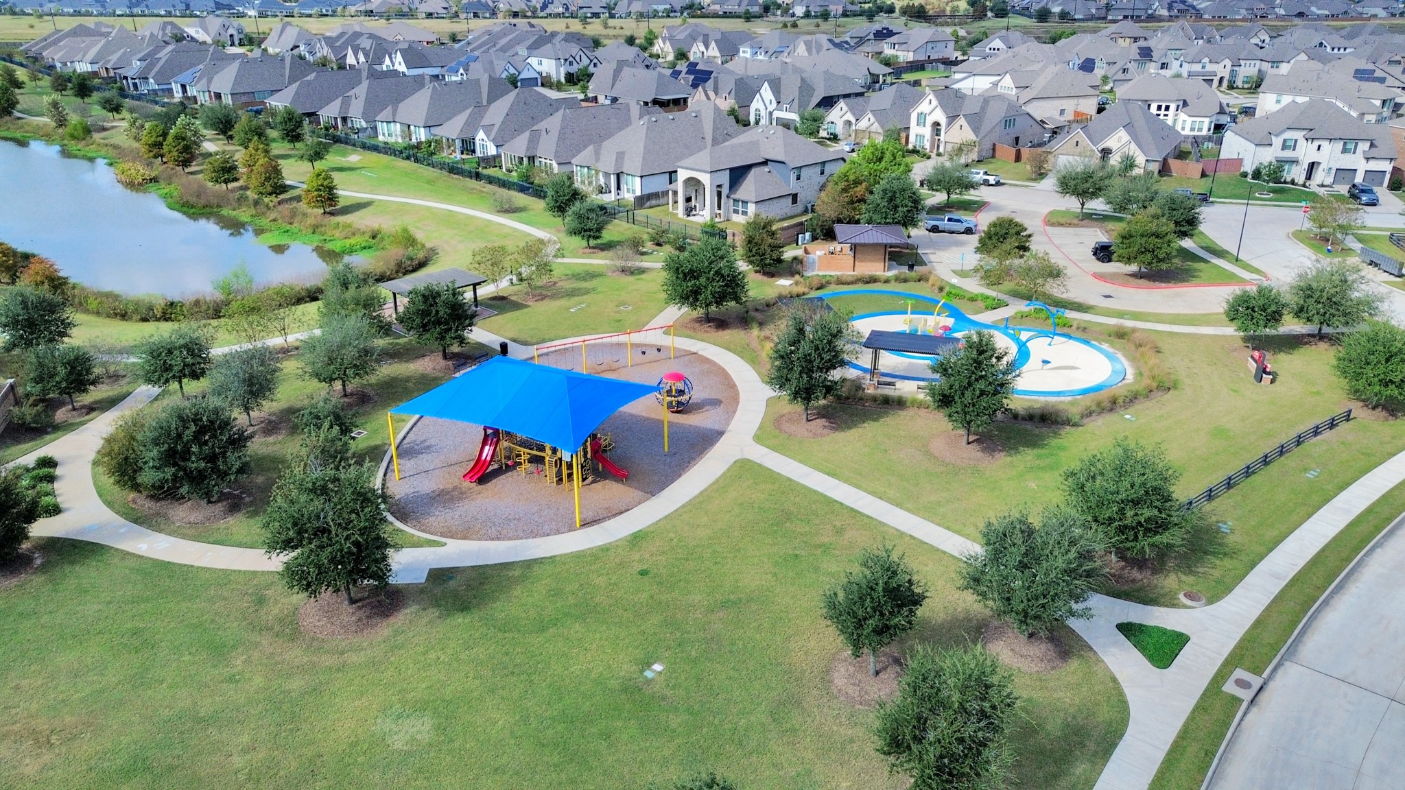 Neighborhood park with playground, splash pad, walking trails, and scenic lake views.