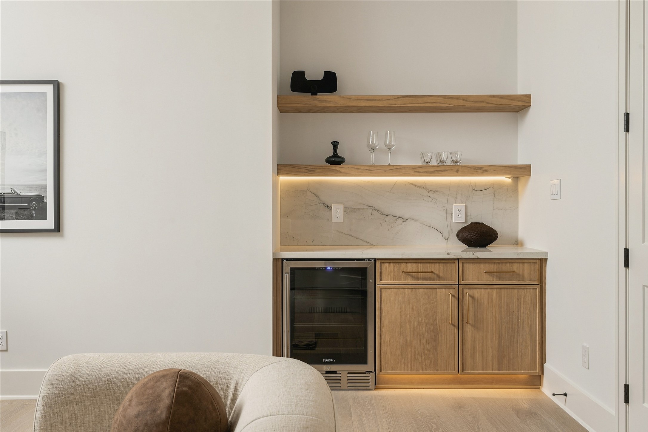 The game rooms custom dry bar is finished with Mount Blanc Quartzite, integrated LED lighting, and a 24-inch beverage coolerkeeping refreshments conveniently within the upstairs entertaining space.