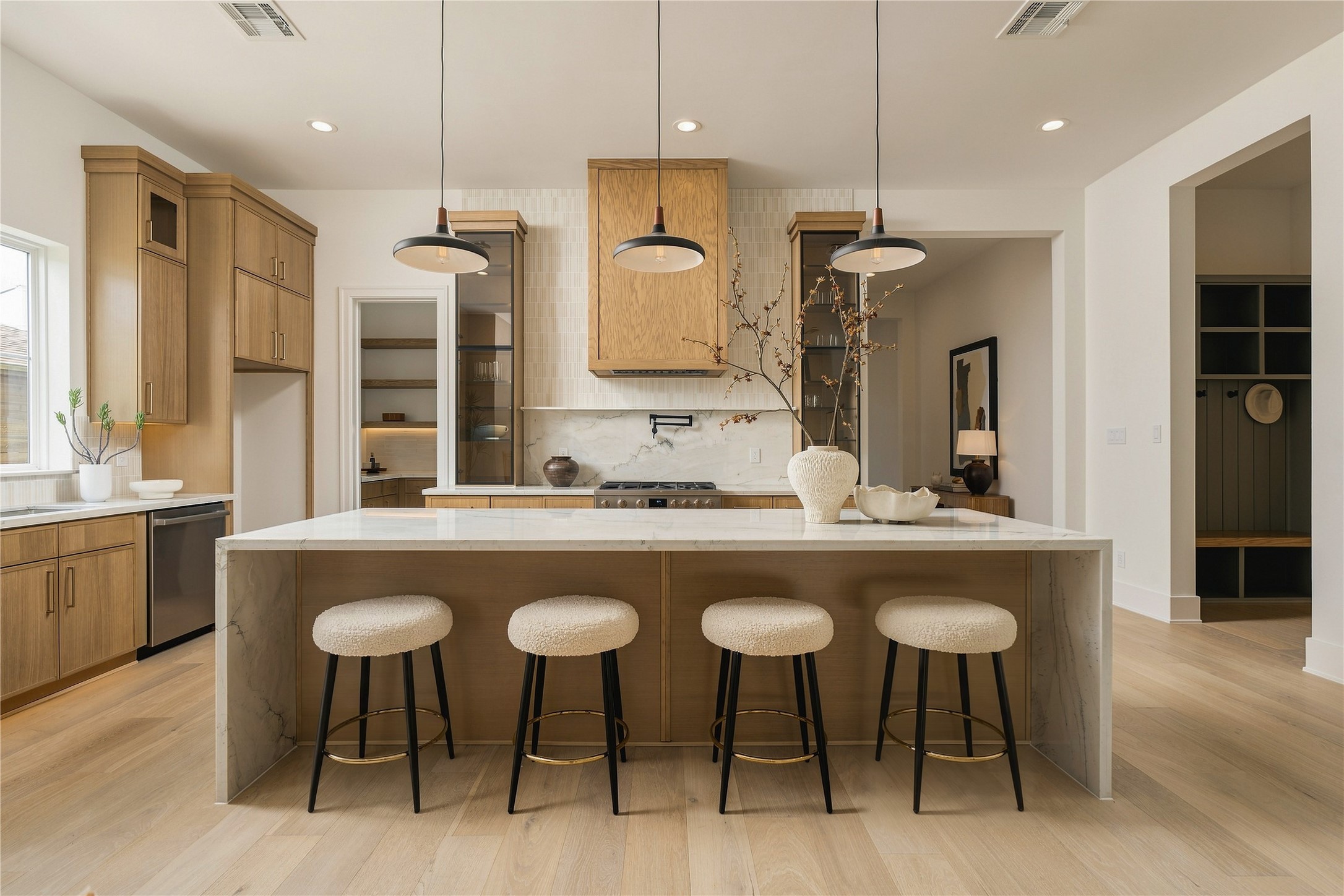 A front-facing view highlights the kitchens symmetry and tailored composition, with the oversized island anchoring the space and seating five comfortably for casual dining and conversation.