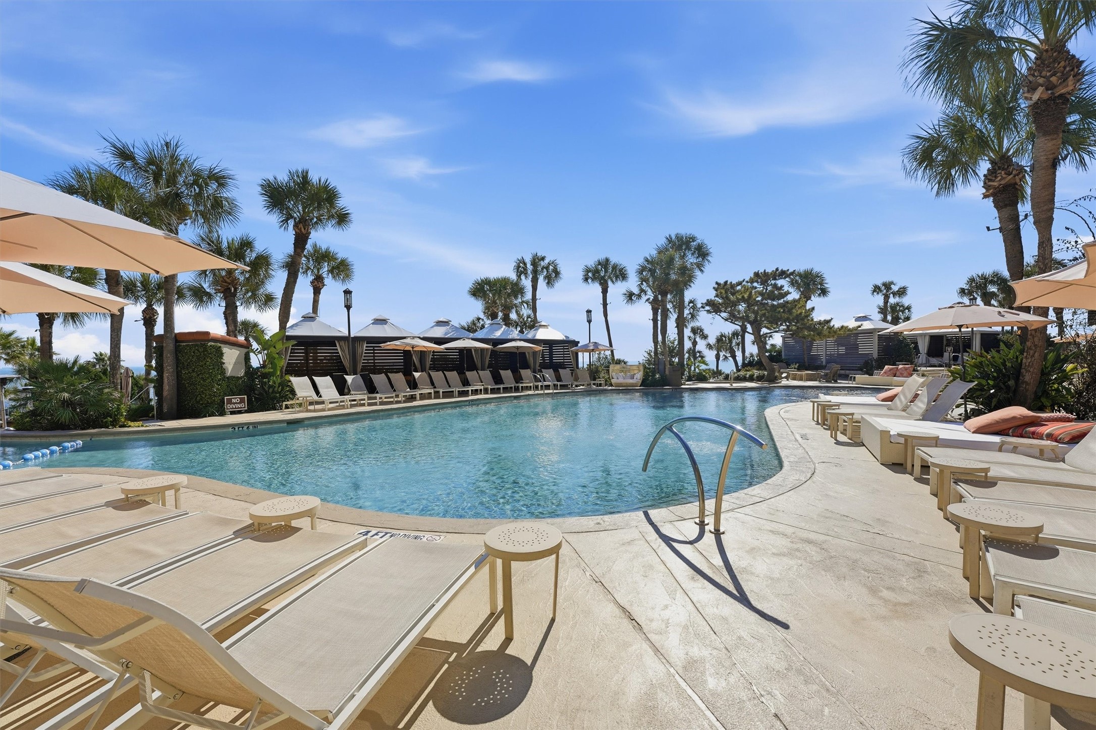 A resort-style pool area offers an inviting place to unwind, soak up the coastal atmosphere, and enjoy beautifully maintained grounds just steps from the beach.