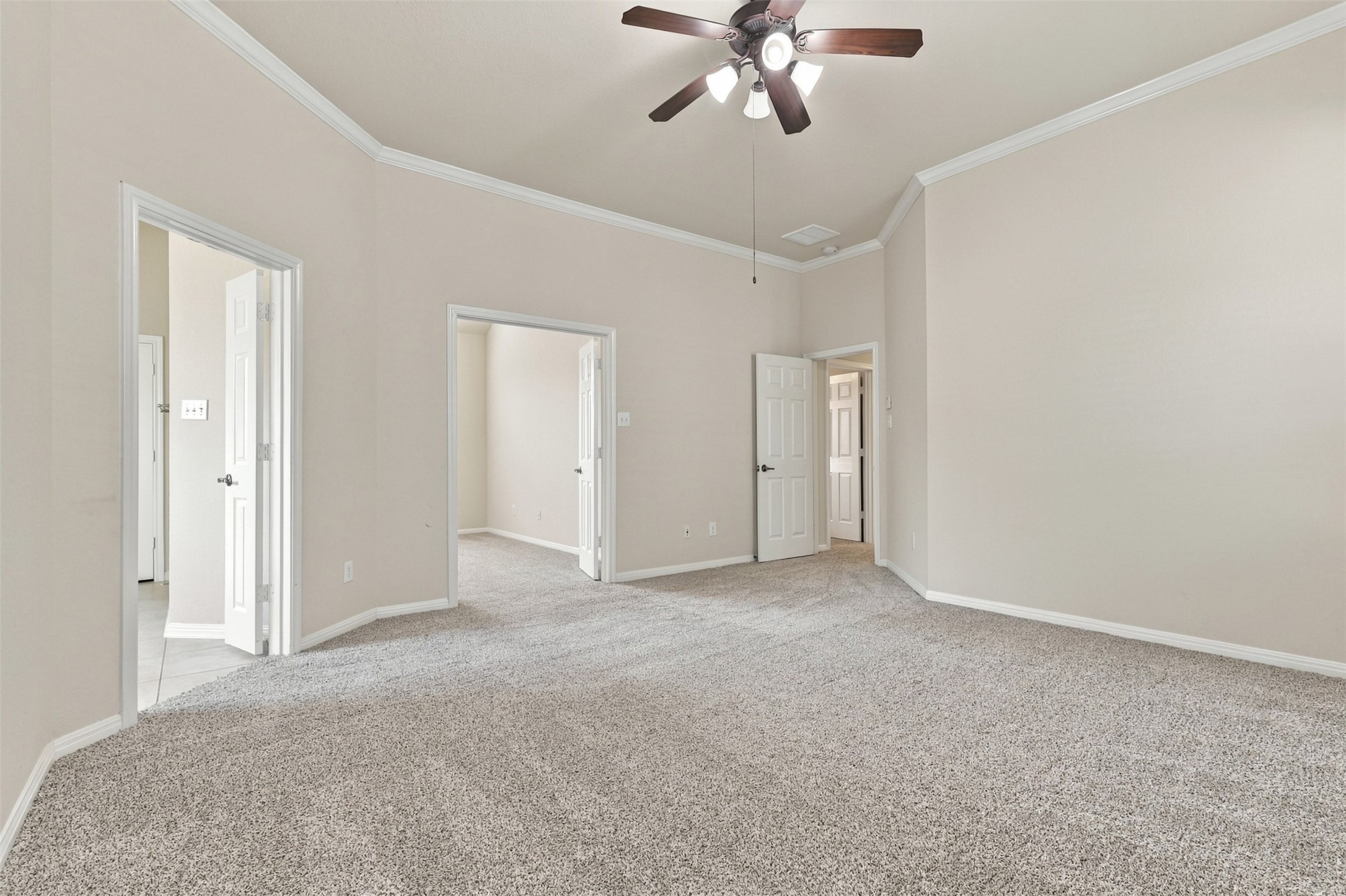 Spacious primary room with plush carpeting, neutral walls, and a ceiling fan, with views into the flex room.