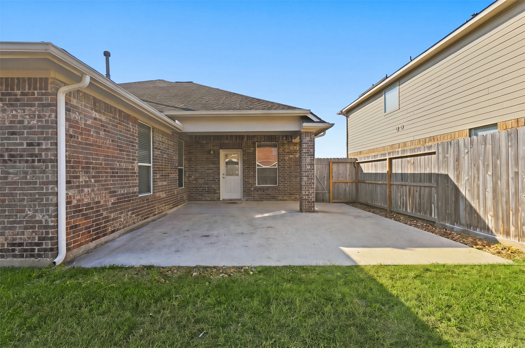 Spacious backyard with a covered patio, perfect for outdoor gatherings and relaxation.