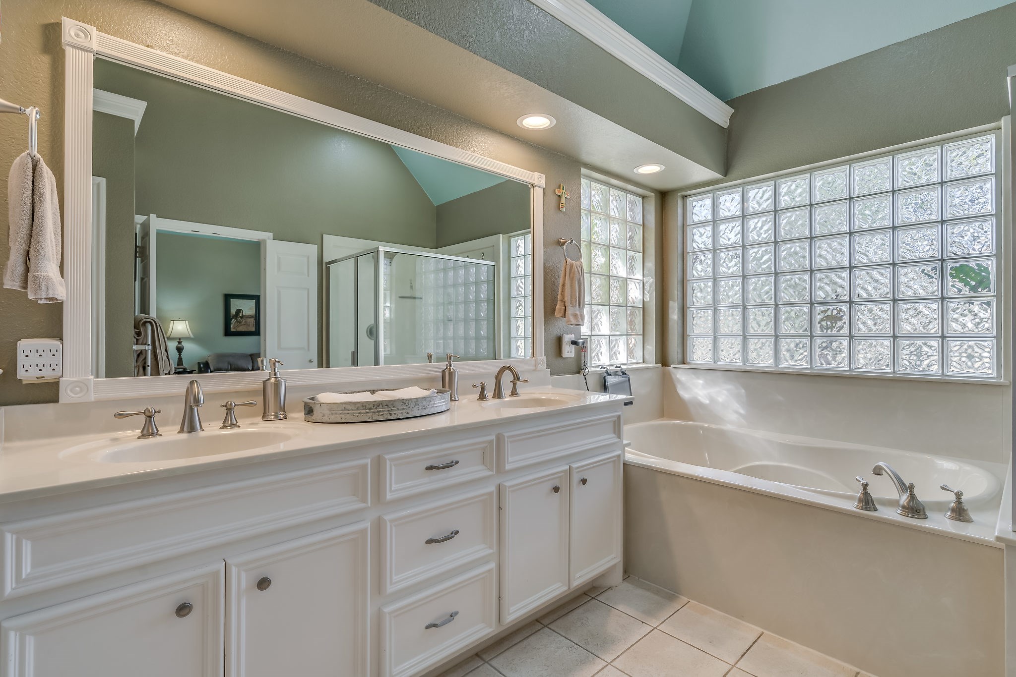Discover your oasis in this spacious primary bath featuring elegant double vanities, a generous closet, and stylish tile flooring