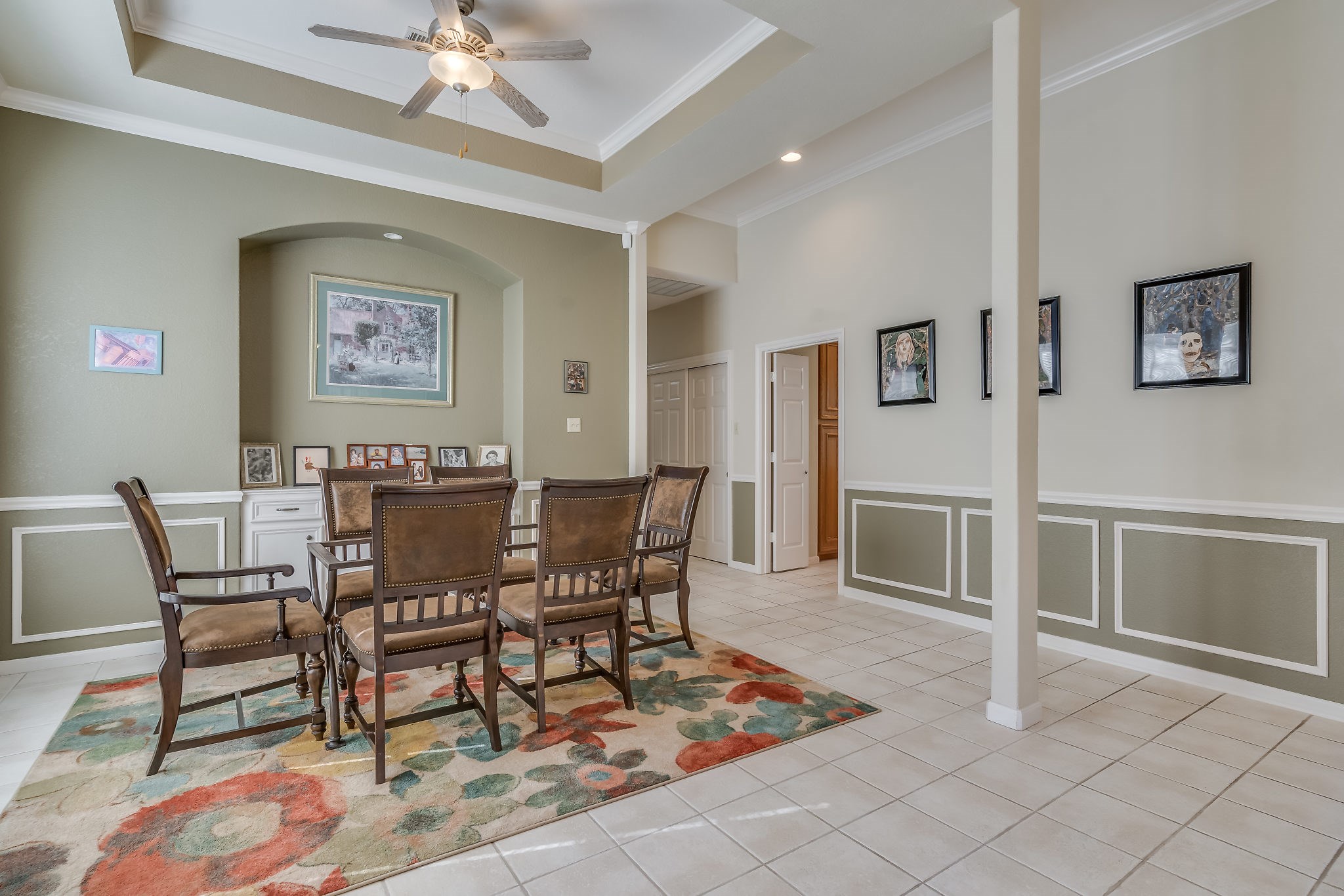 Discover elegance in this formal dining area, featuring a ceiling fan, lighted art niche, stylish trim, and tiled flooringperfect for memorable gatherings