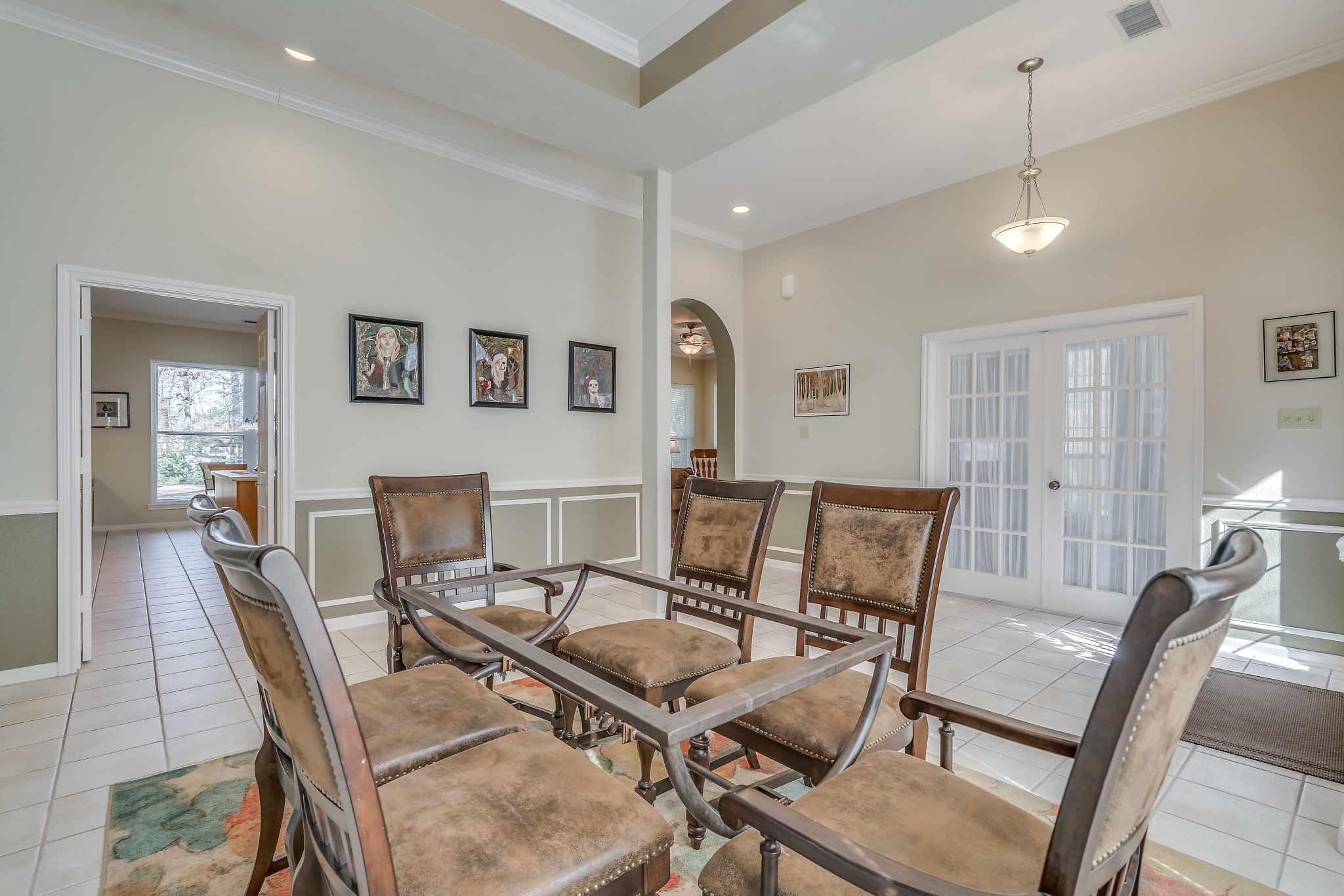 Discover a bright and inviting dining area and foyer seamlessly leading to the kitchen and family room, with a cozy study tucked behind elegant French doors