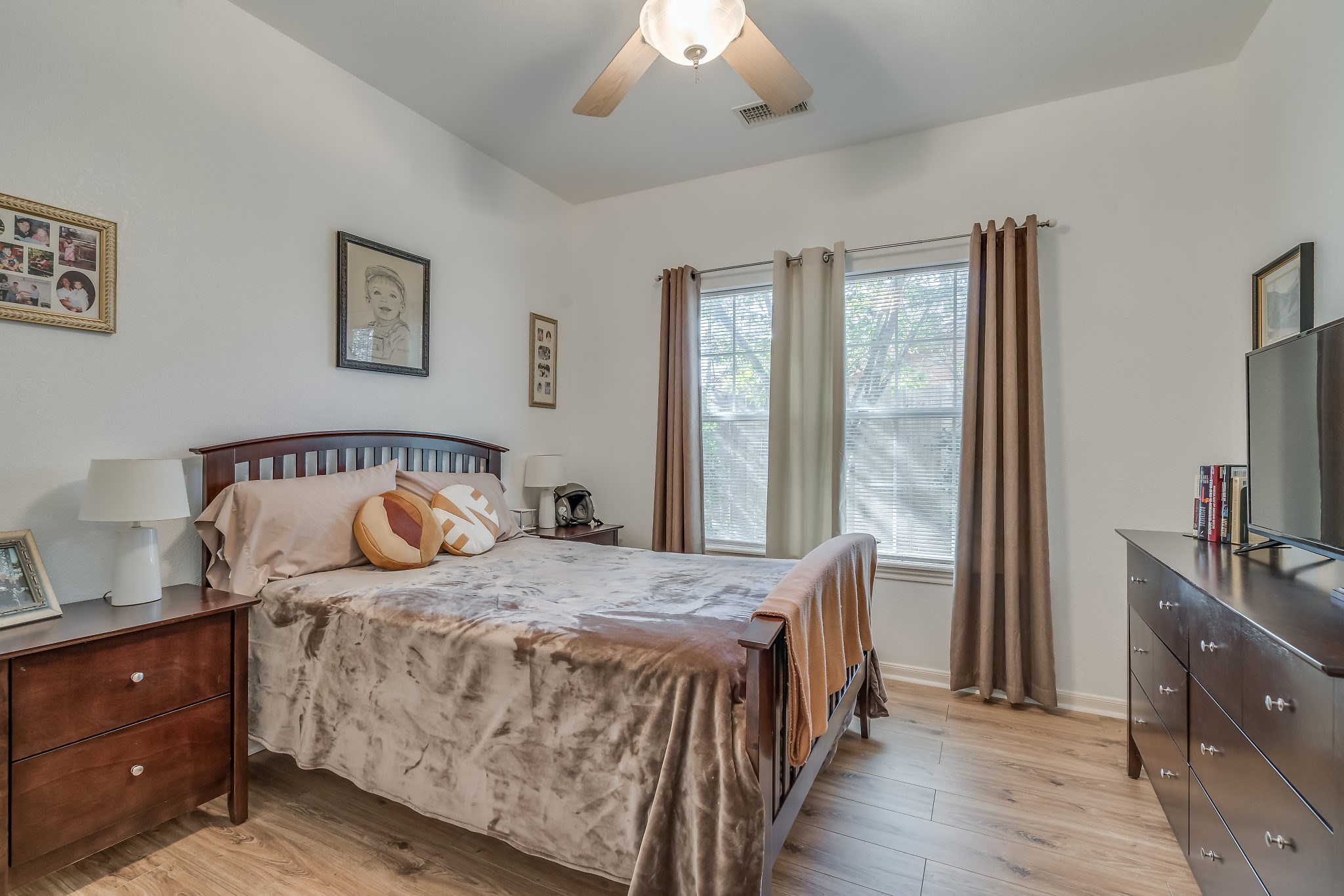 Experience comfort and style in Bedroom 2, featuring ceiling fan and laminate wood floors