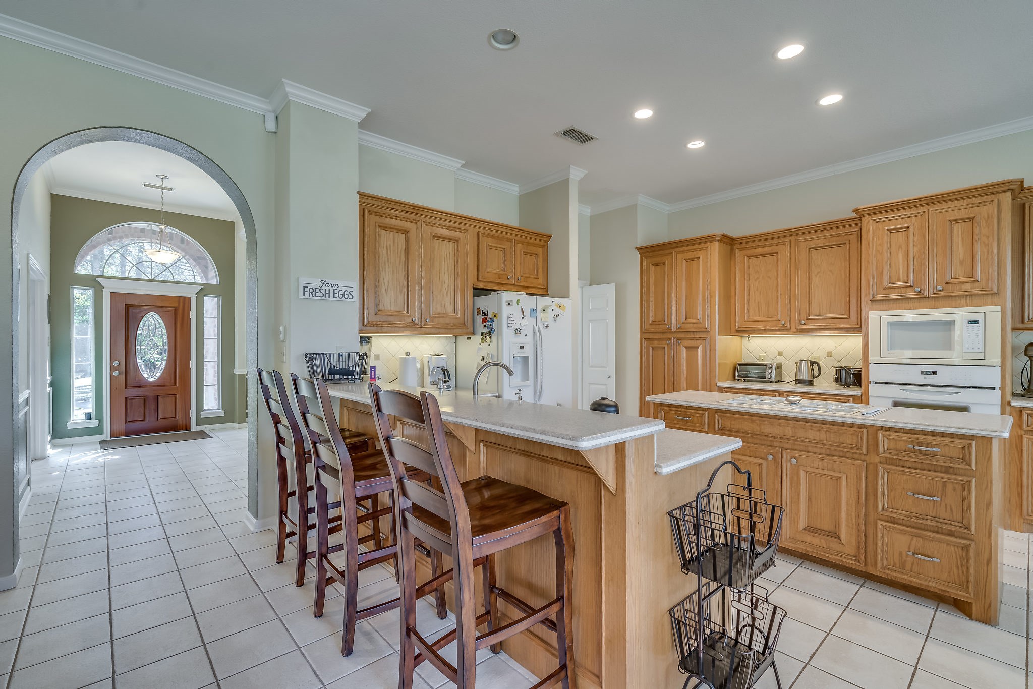 Discover culinary delight in this gourmet kitchen, featuring abundant cabinetry, a spacious island, and an oversized breakfast bar perfect for eating small meals or displaying gourmet foods for quests