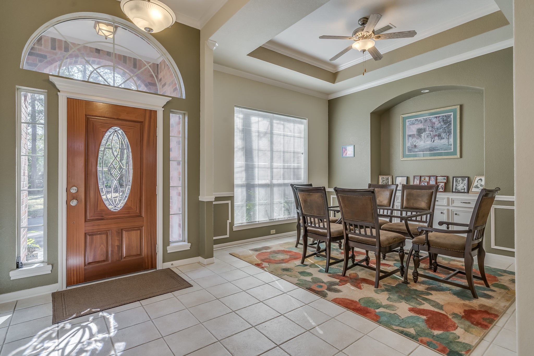 Step into an inviting foyer featuring a stunning leaded glass front door with sidelights and transom, complemented by elegant tiled flooring and warm, welcoming colors throughout