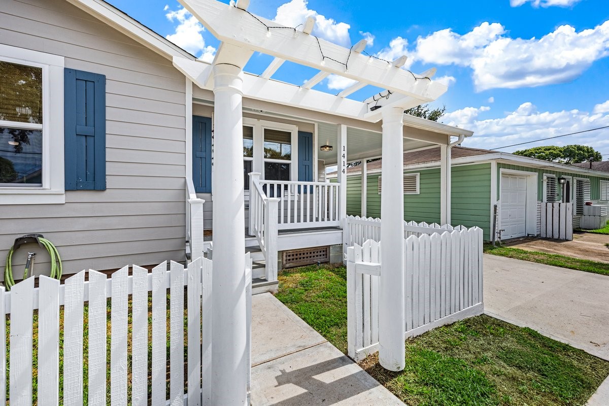 Charming garden arbor entrance adds a welcoming touch to this beautifully remodeled Galveston home.
