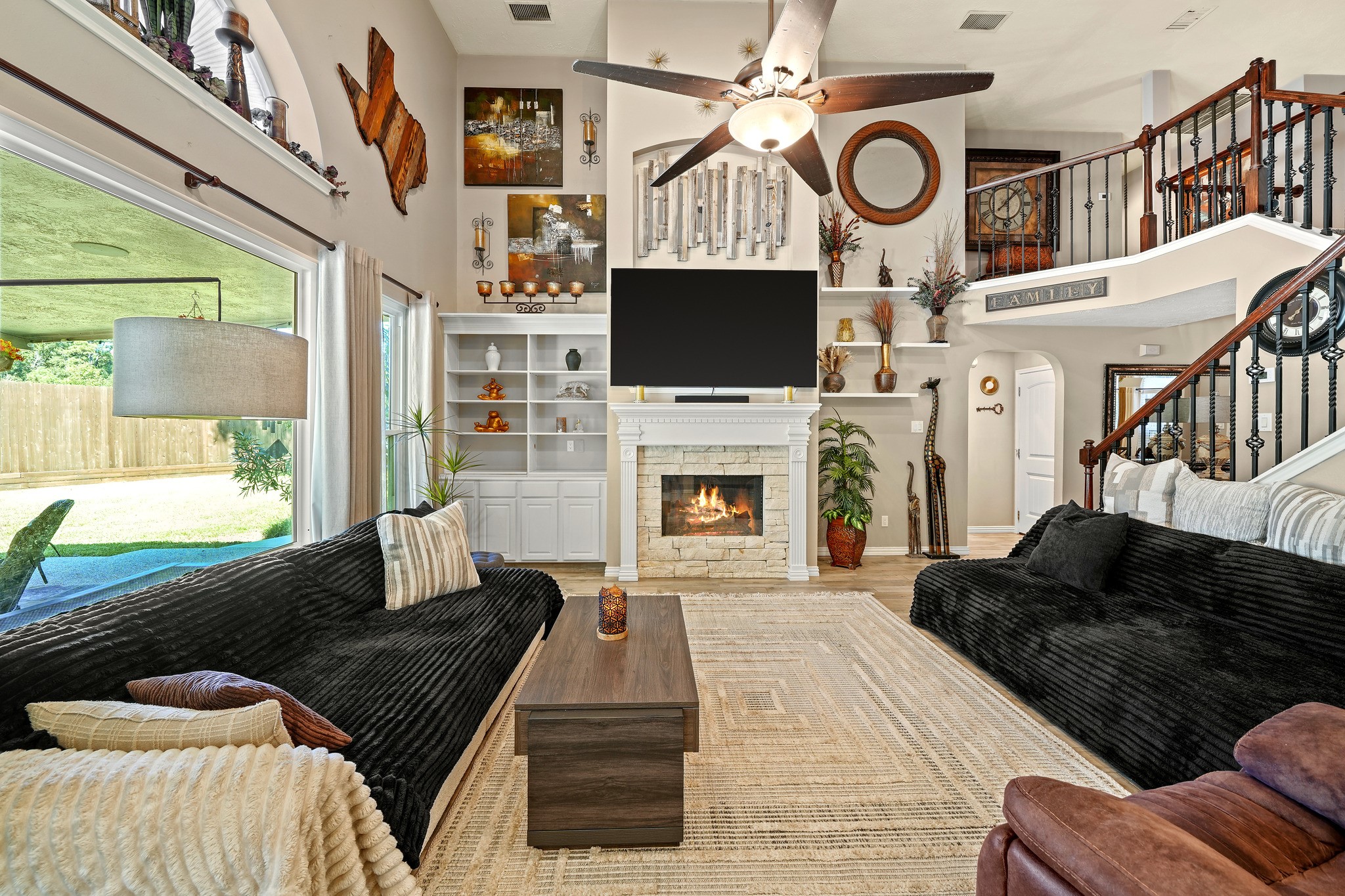 Soaring living room with stone fireplace. Virtually staged.