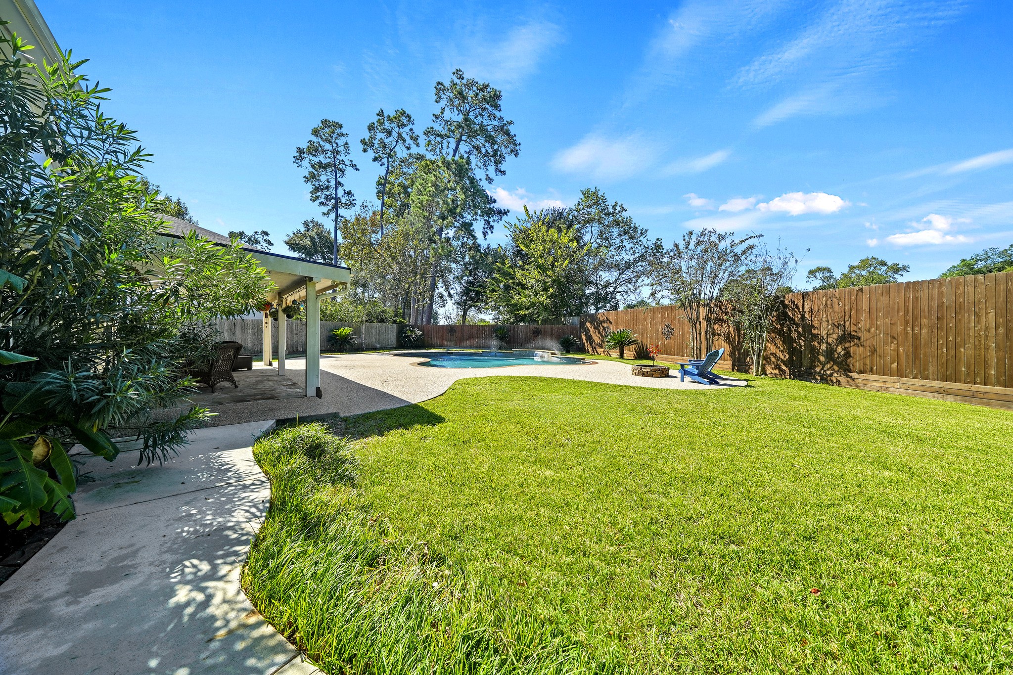 Private fenced backyard with mature trees.