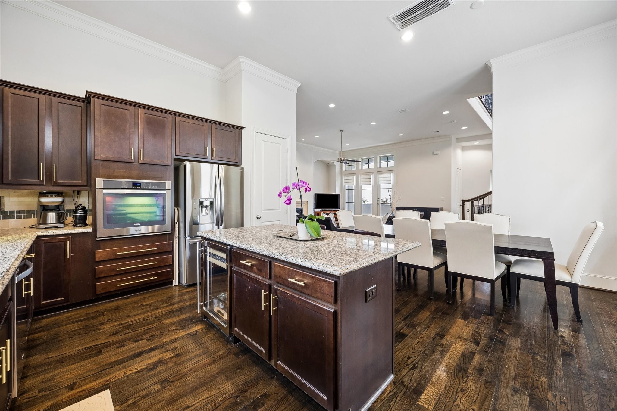 Open sightlines connect the kitchen, dining area, and living room, creating an easy flow for everyday living and entertaining. The oversized island anchors the kitchen with added storage, counter space, and a built in beverage refrigerator.