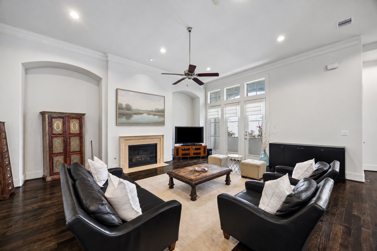 High ceilings and a wall of windows give the main living area an open, light filled feel. A gas fireplace anchors the room.