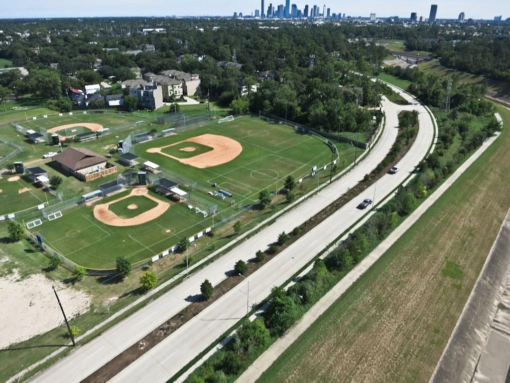 Aerial view of Heights Hike & Bike Trail running alongside neighborhood athletic fields, offering direct access to outdoor recreation with downtown Houston visible in the distance.