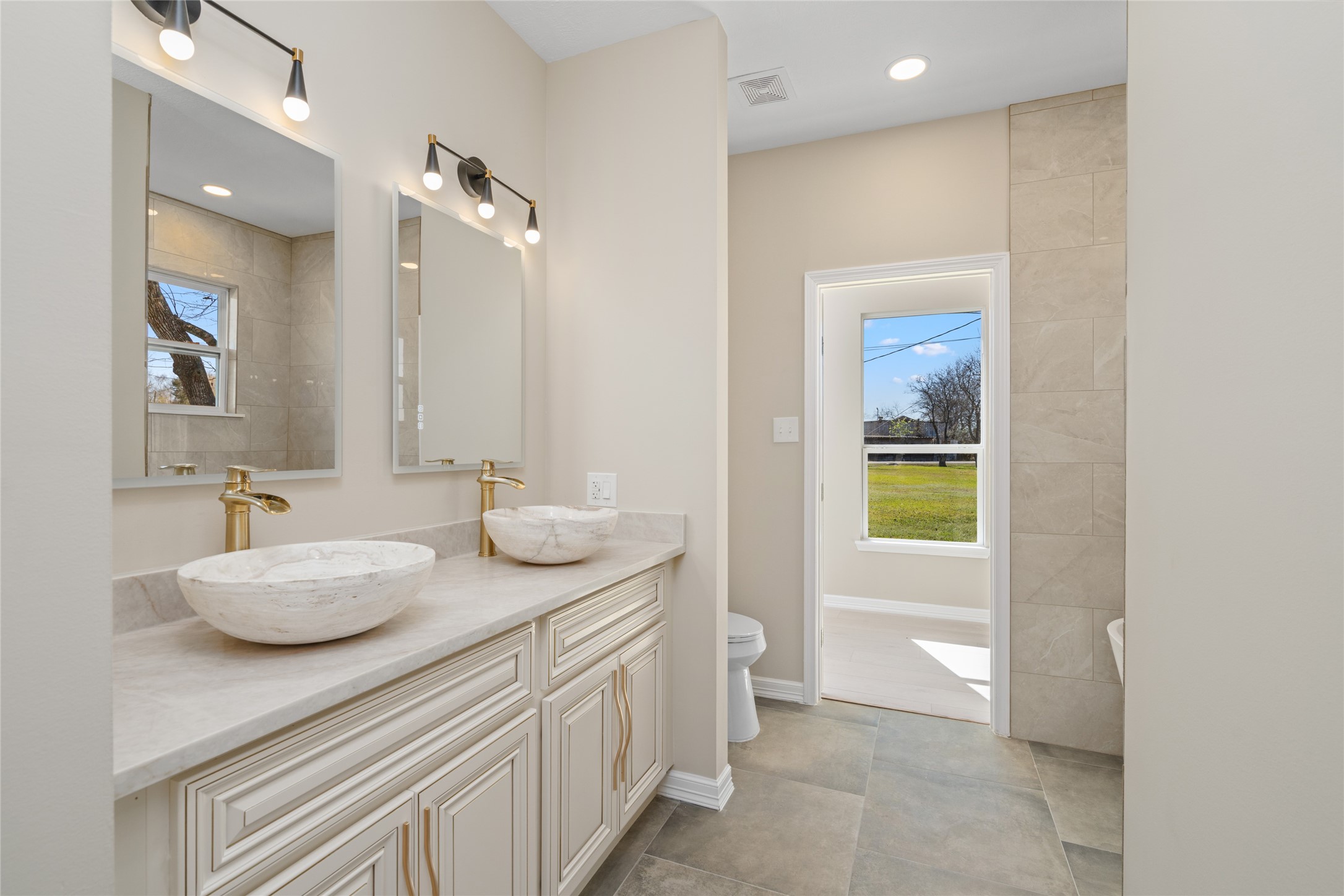 Luxurious master bath
retreat with dual vessel
sinks, elegant vanity, and a
spa-like ambiance. Natural
light flows in, creating a
serene start to your day."